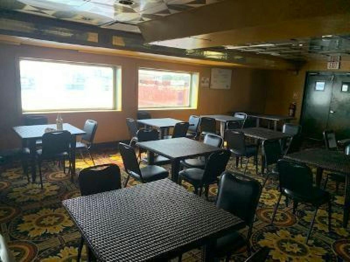 a room with tables and chairs aboard No Name Yacht for Sale