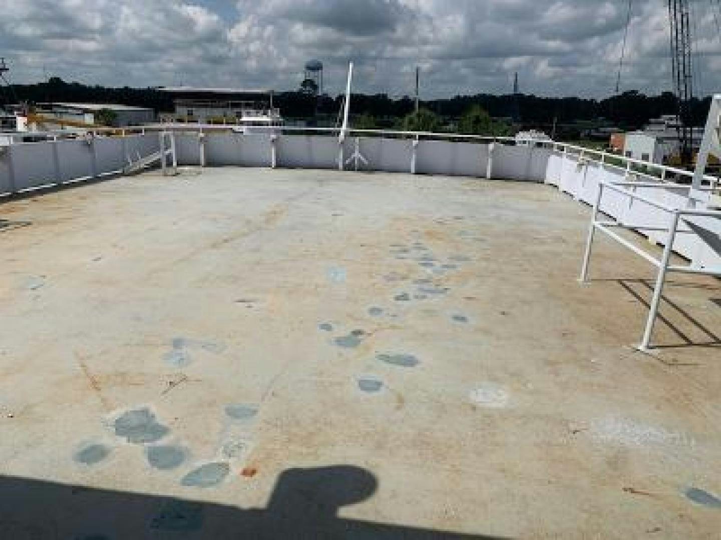 a large concrete area with a concrete wall and a building in the background aboard No Name Yacht for Sale