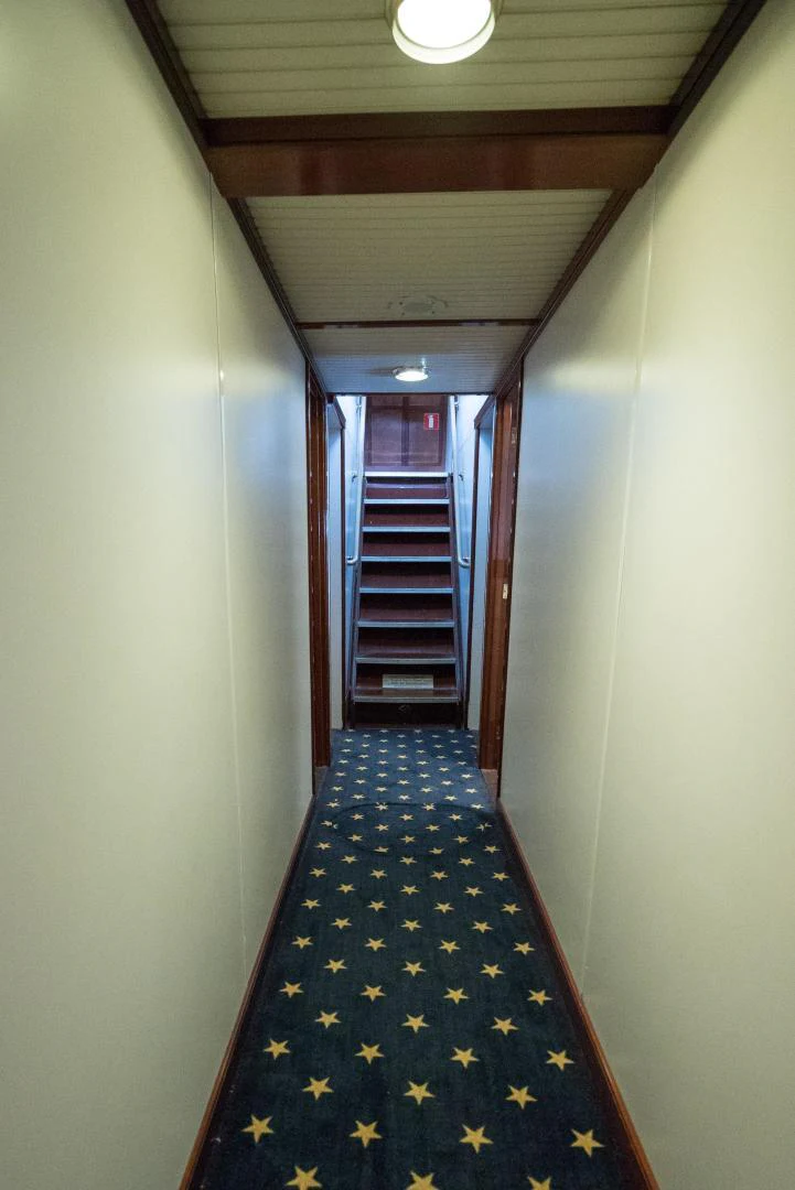 a hallway with a blue and white checkered rug aboard ARABELLA Yacht for Sale