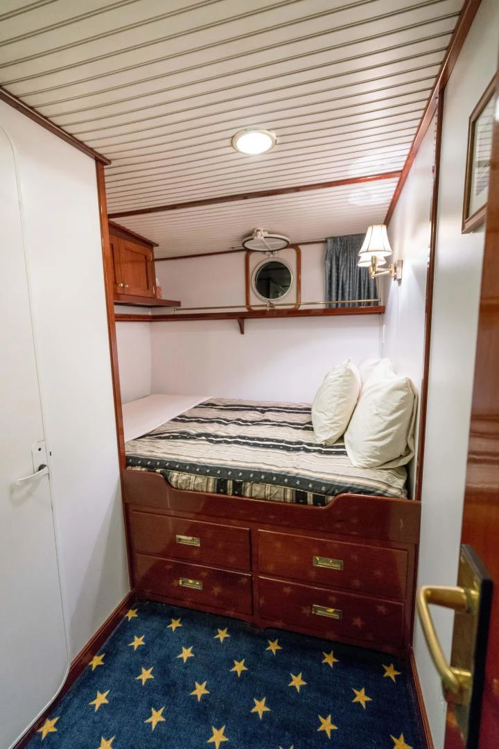 a bedroom with a bed and a mirror aboard ARABELLA Yacht for Sale