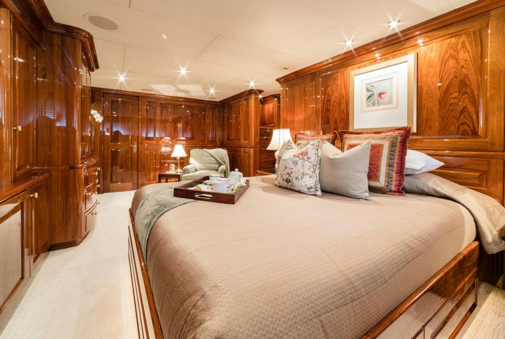a bed with pillows and a chair aboard POPEYE Yacht for Sale