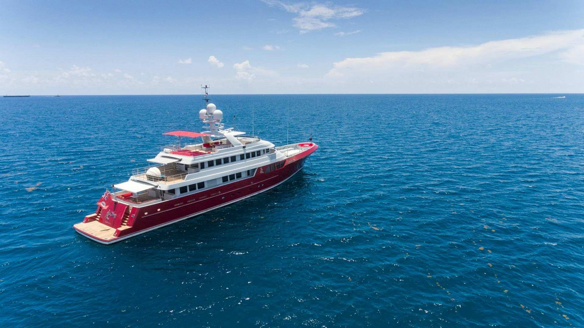 a red and white boat in the water aboard QING Yacht for Sale