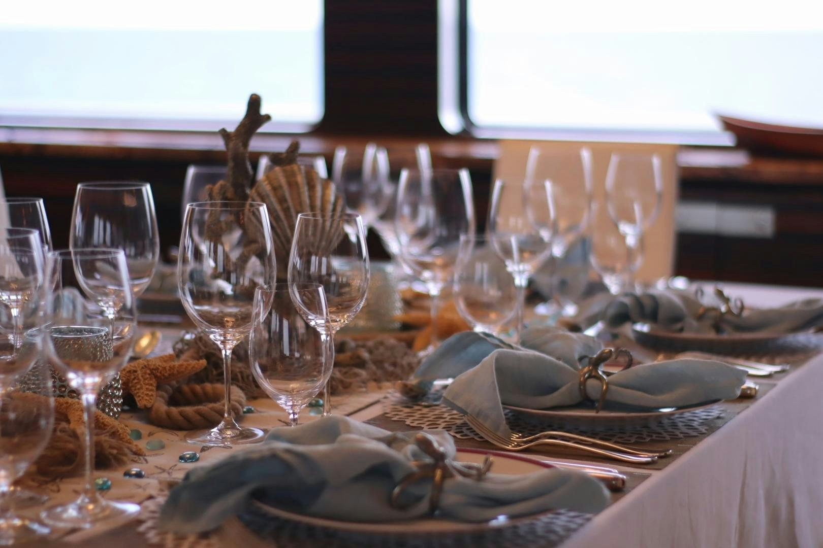 a table with wine glasses and plates aboard QING Yacht for Sale
