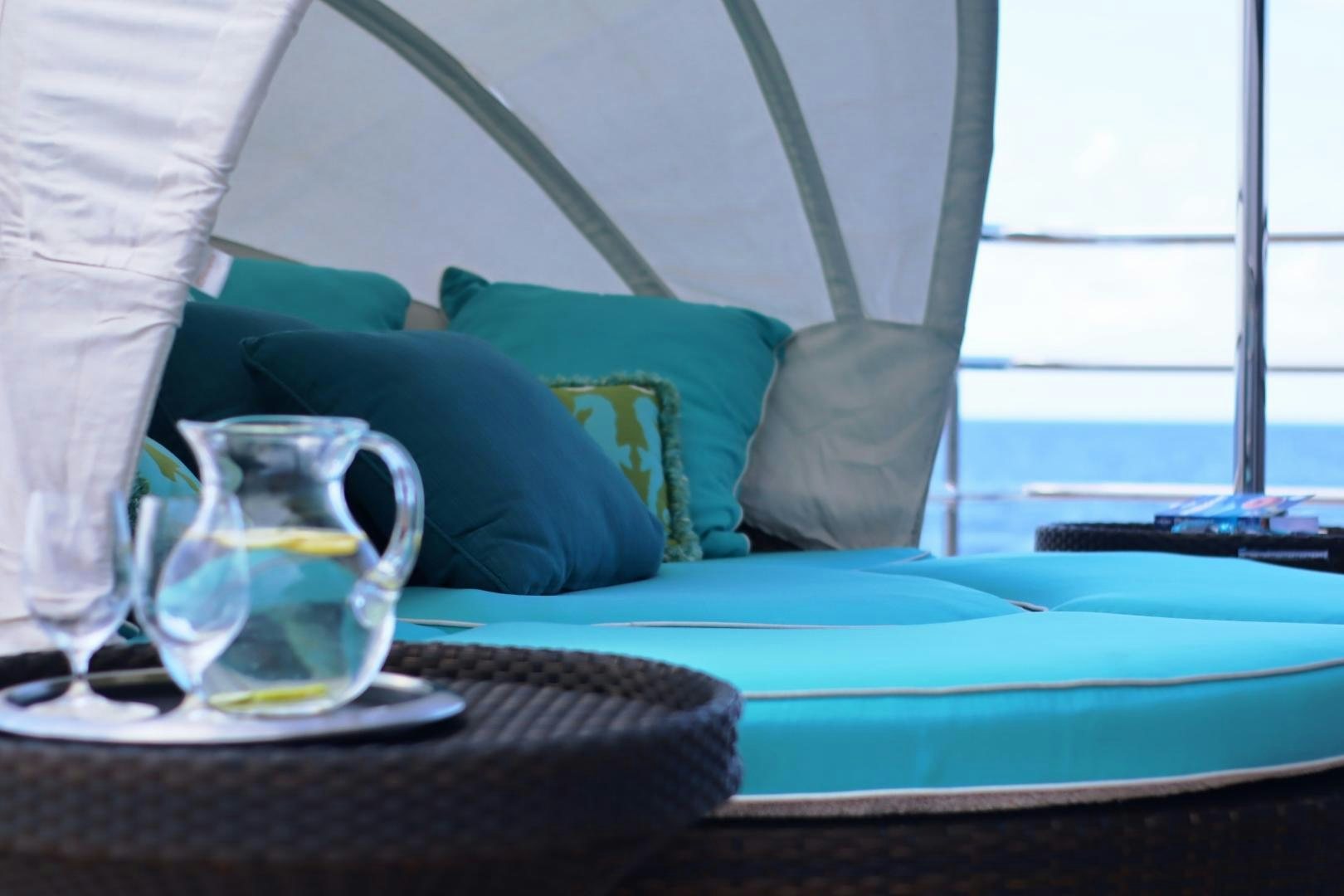 a glass of water on a bed aboard QING Yacht for Sale