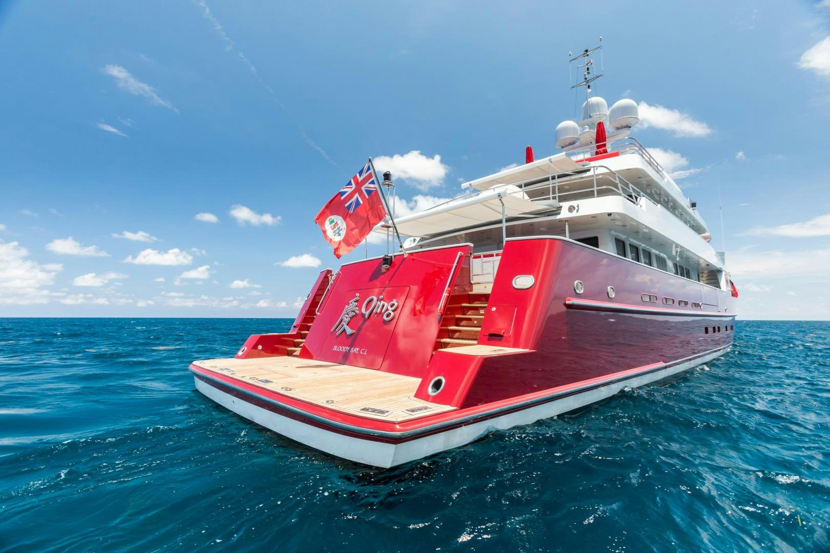 a red and white boat in the water aboard QING Yacht for Sale