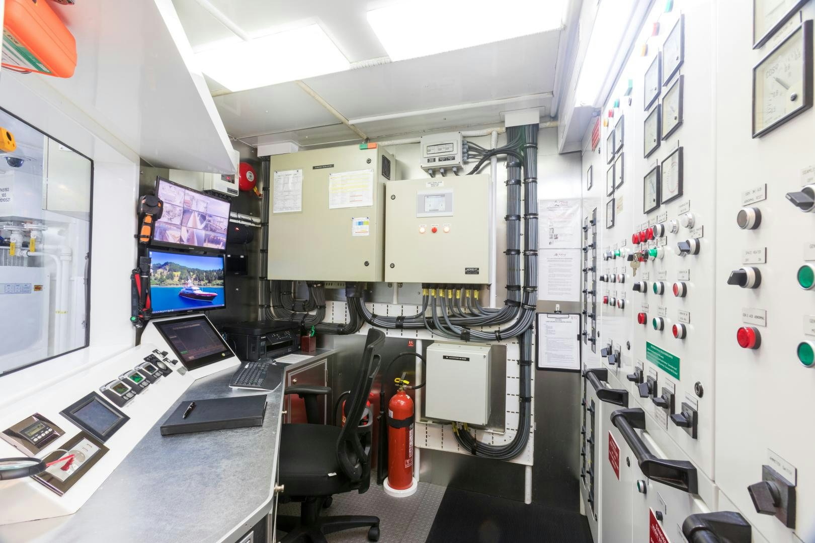 a room with computers and monitors aboard QING Yacht for Sale
