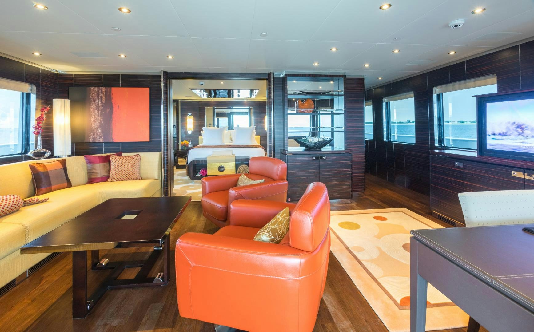 a living room with orange couches aboard QING Yacht for Sale