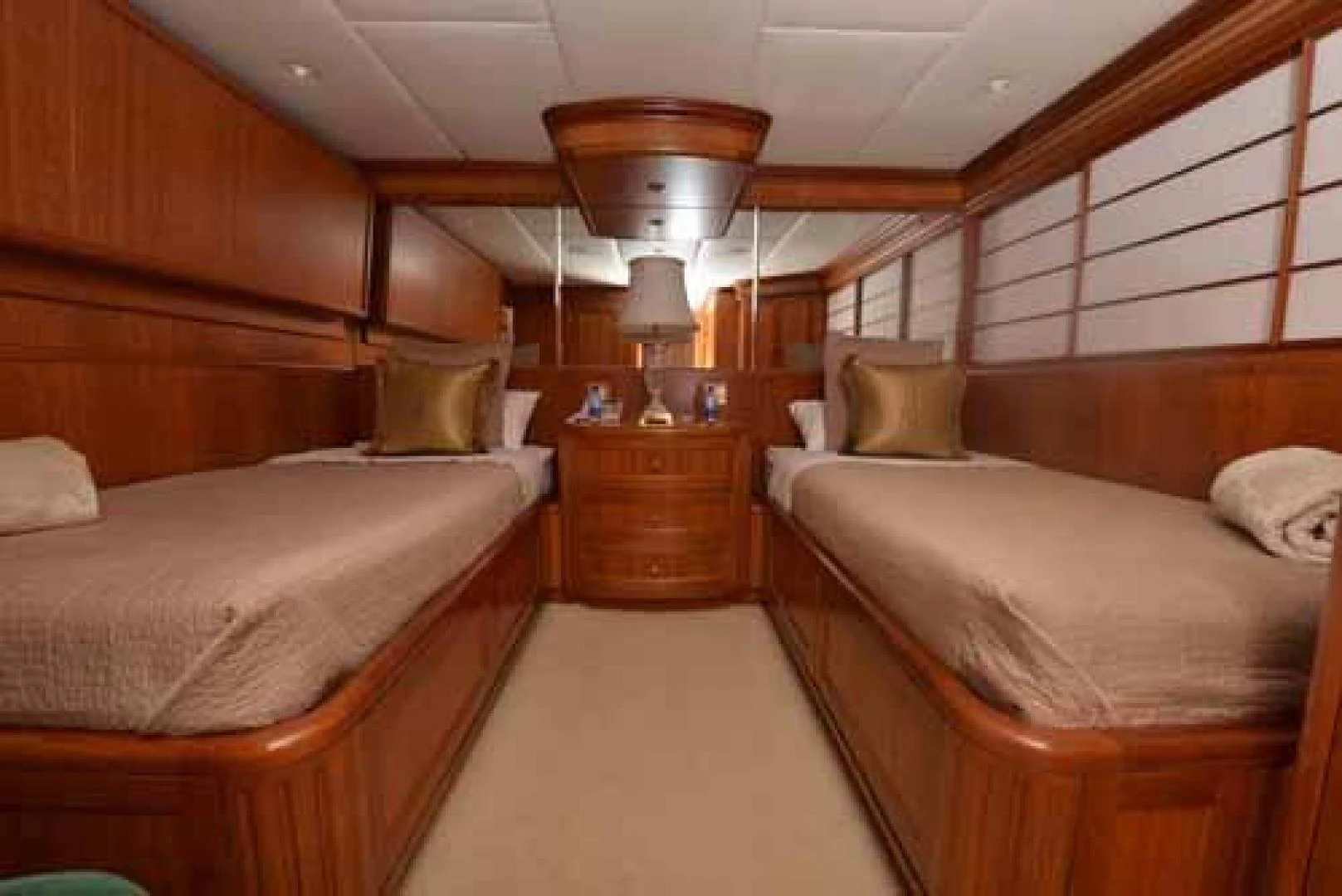 a room with beds and a lamp aboard UTOPIA III Yacht for Sale