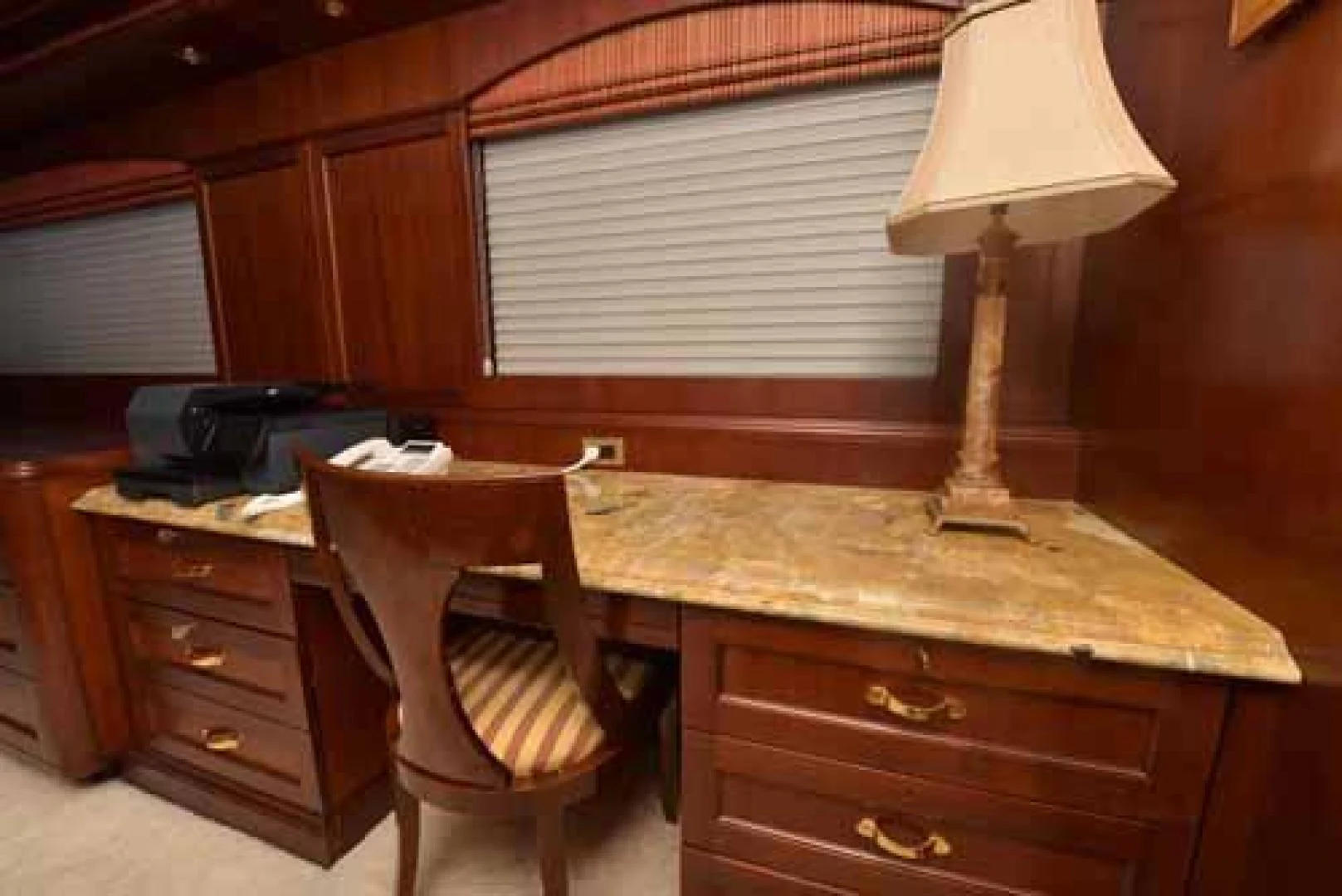 a desk with a lamp and a chair in a room aboard UTOPIA III Yacht for Sale