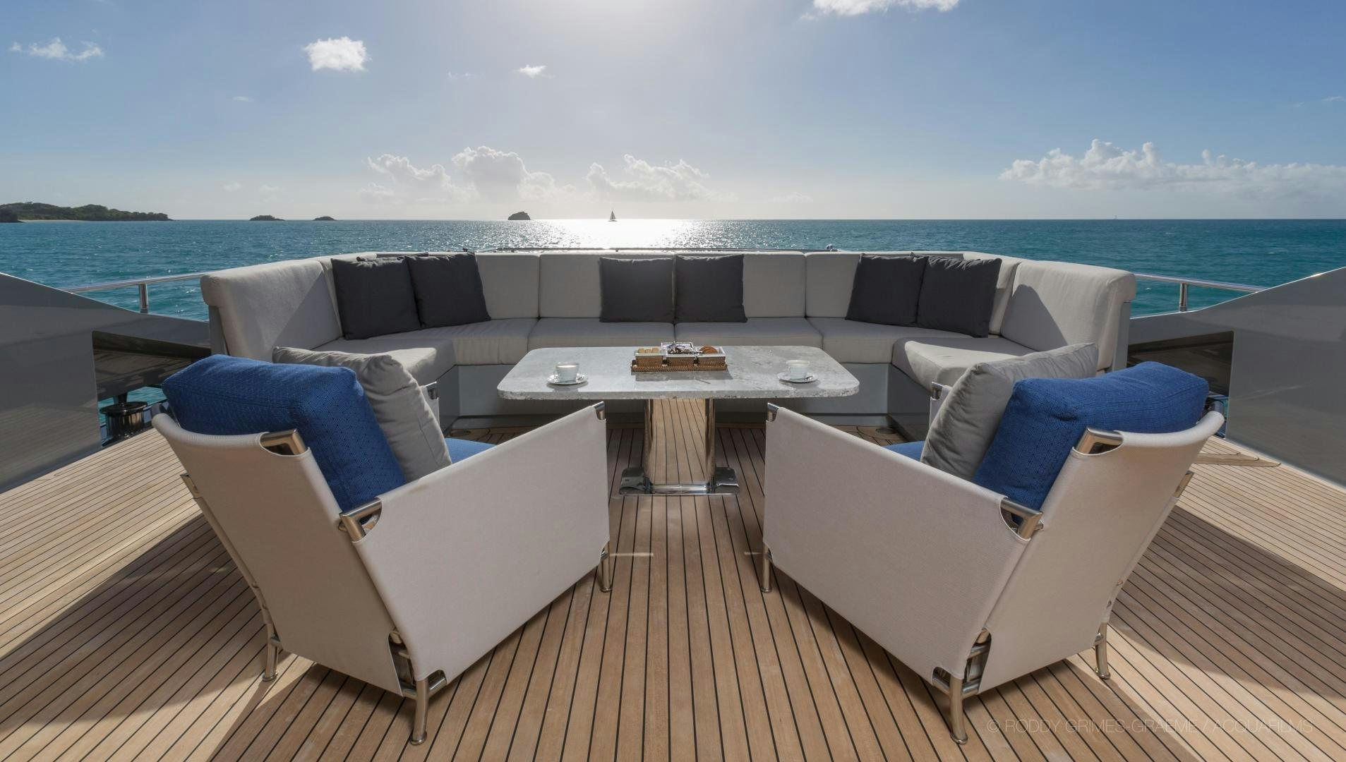 a deck with chairs and a table on it aboard AQUANOVA Yacht for Sale