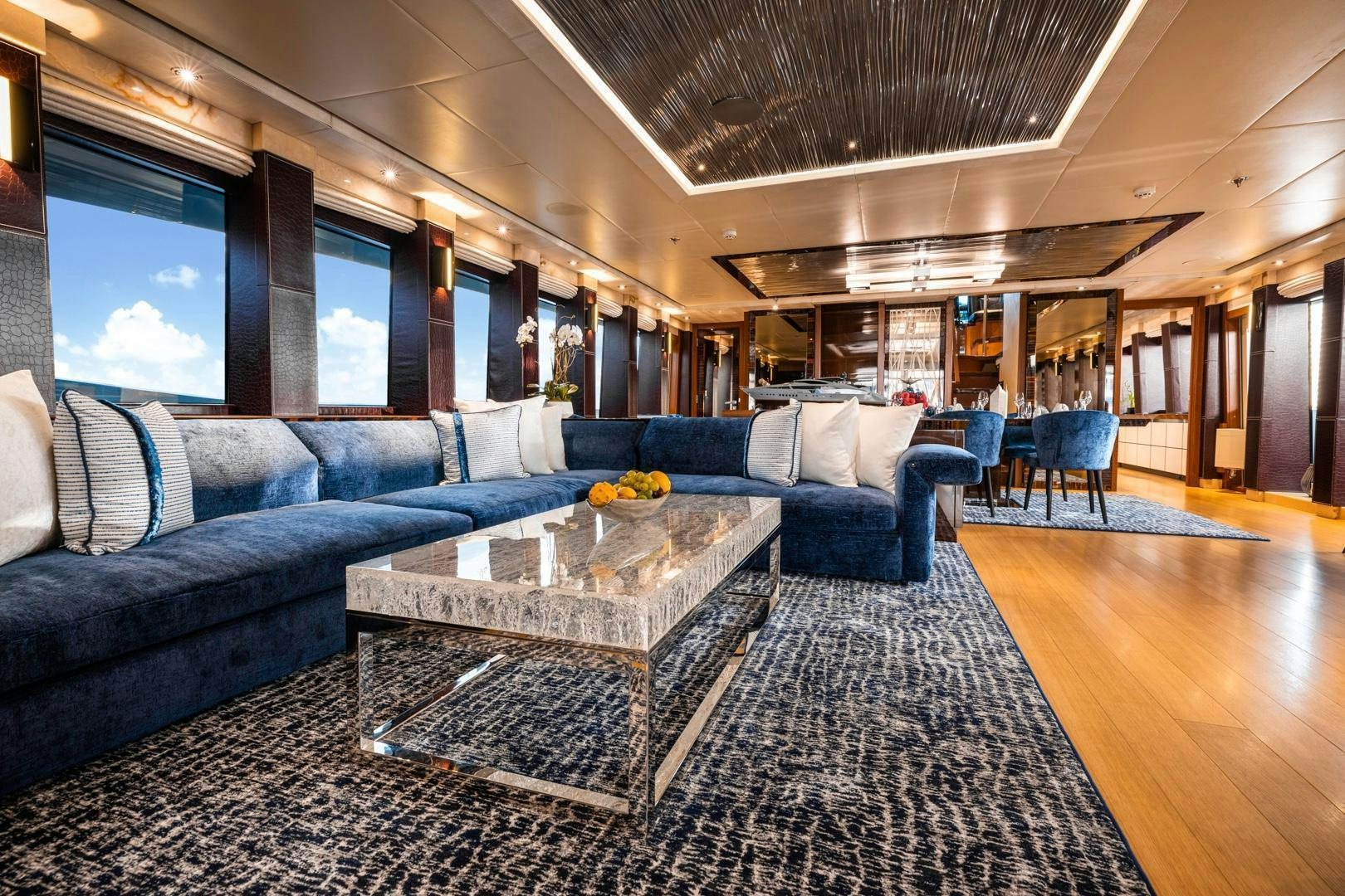 a living room with a large sectional sofa and a coffee table aboard AQUANOVA Yacht for Sale
