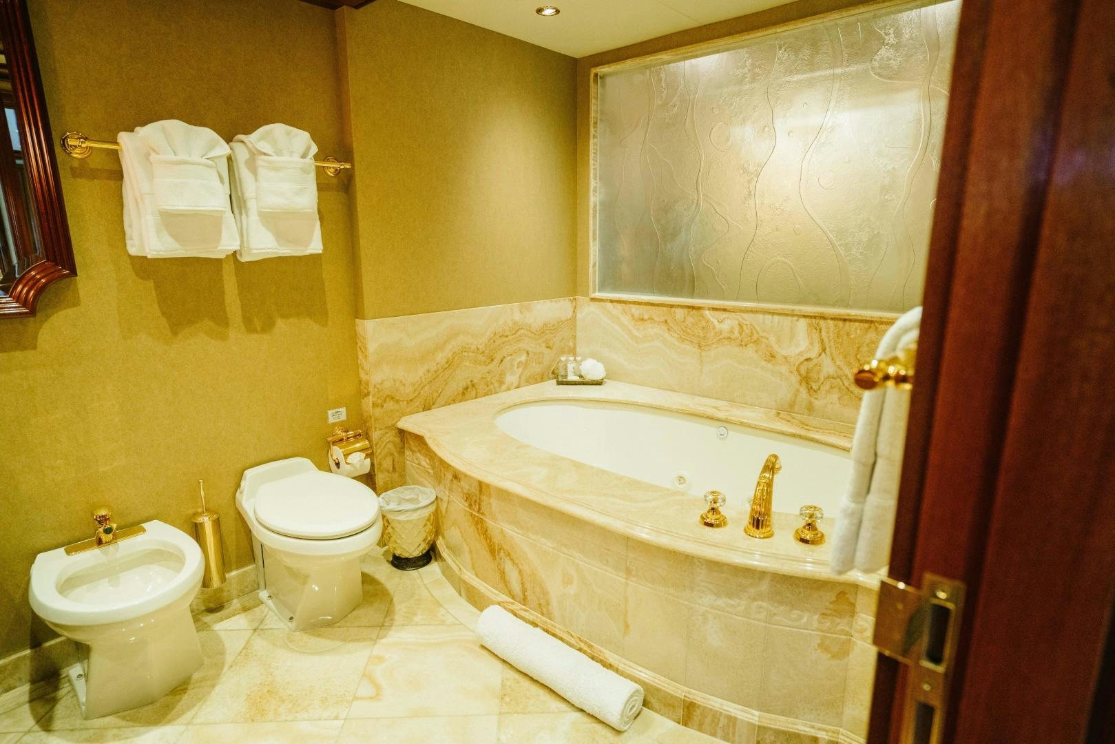 a bathroom with a tub toilet and sink aboard EXCELLENCE Yacht for Sale