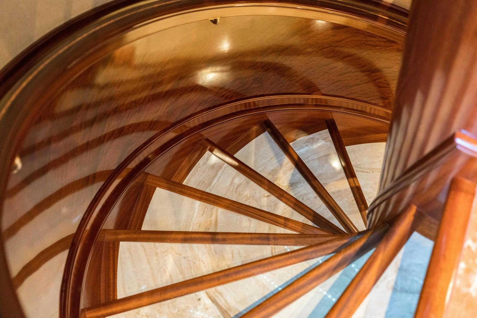 a wooden spiral staircase aboard EXCELLENCE Yacht for Sale