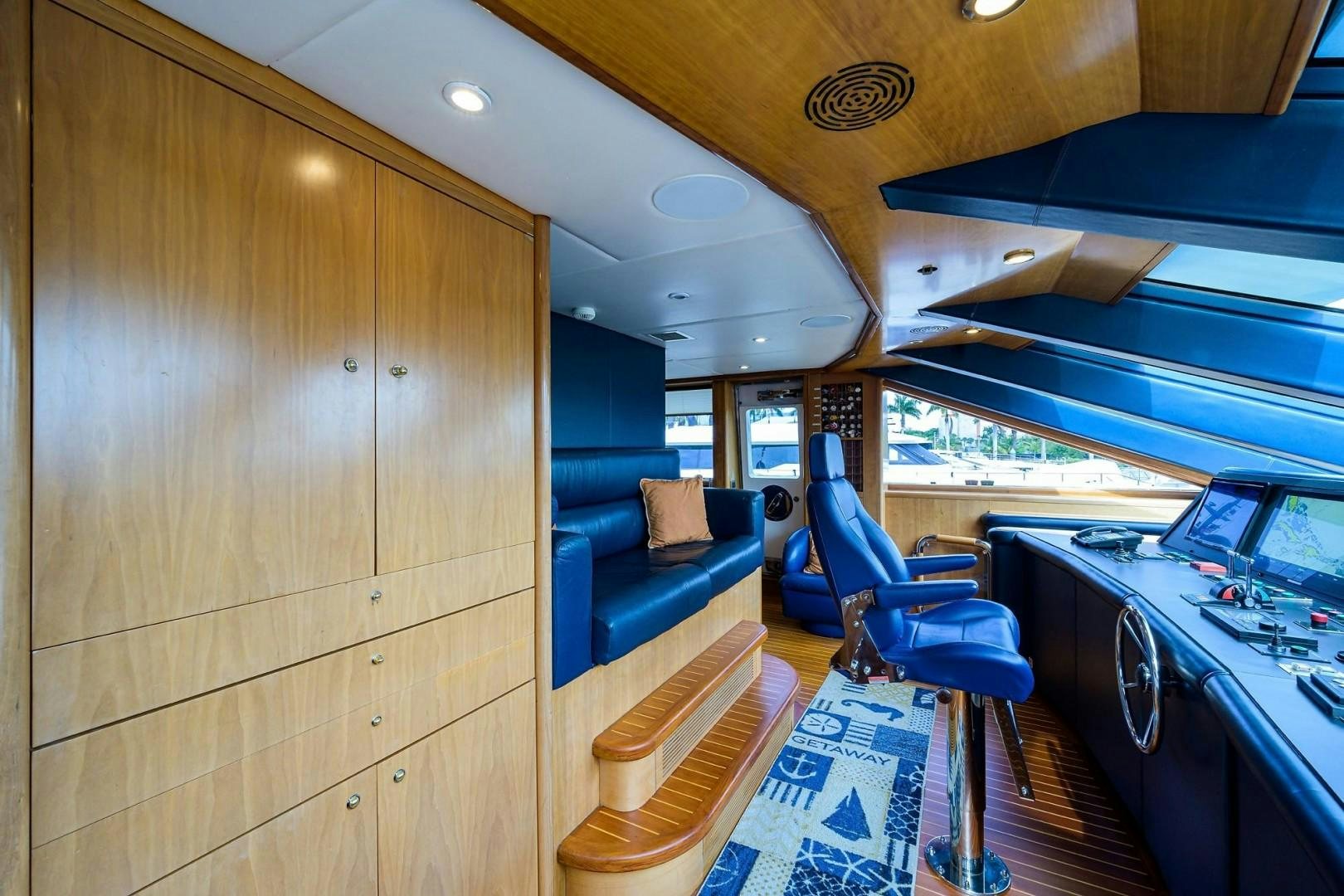a room with a large wood cabinet and a table with chairs aboard CABERNET Yacht for Sale