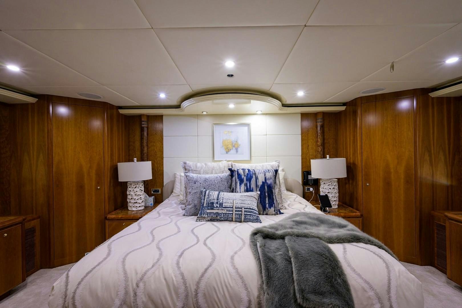 a bedroom with a bed and a lamp aboard CABERNET Yacht for Sale