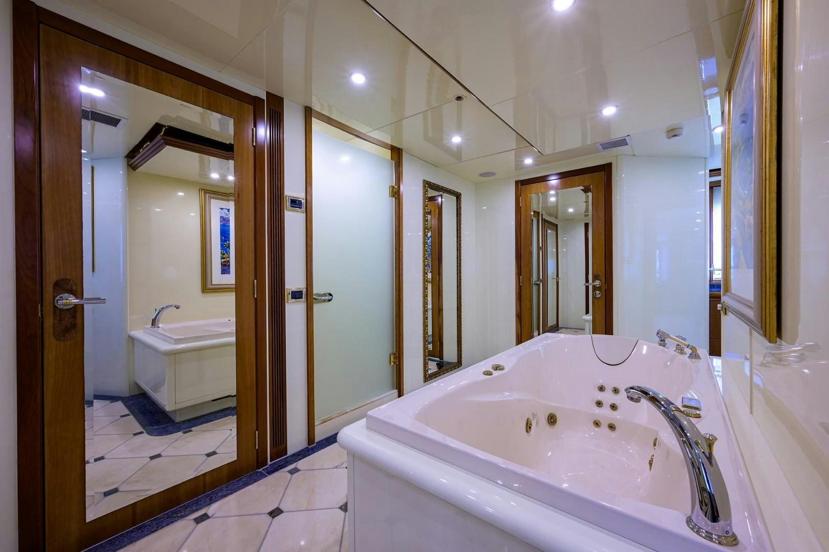 a bathroom with a bathtub and sinks aboard CABERNET Yacht for Sale