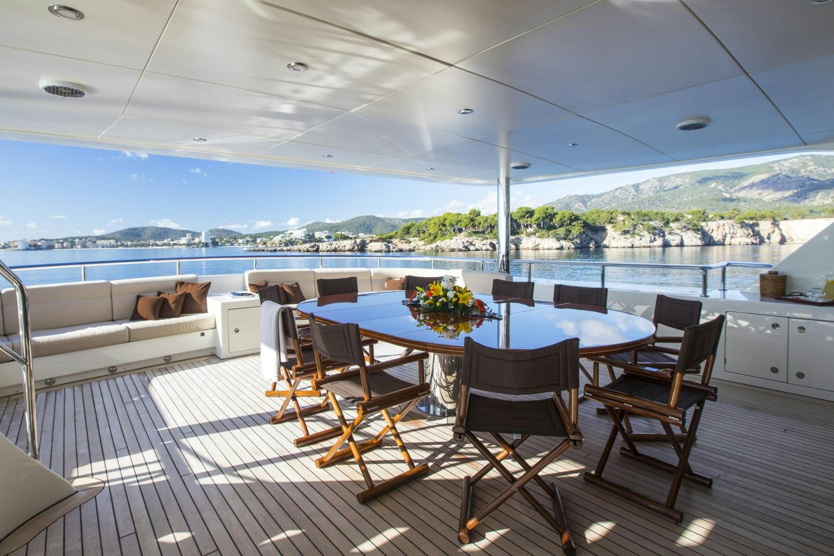a large patio with a table and chairs and a large body of water aboard DYNASTY Yacht for Sale