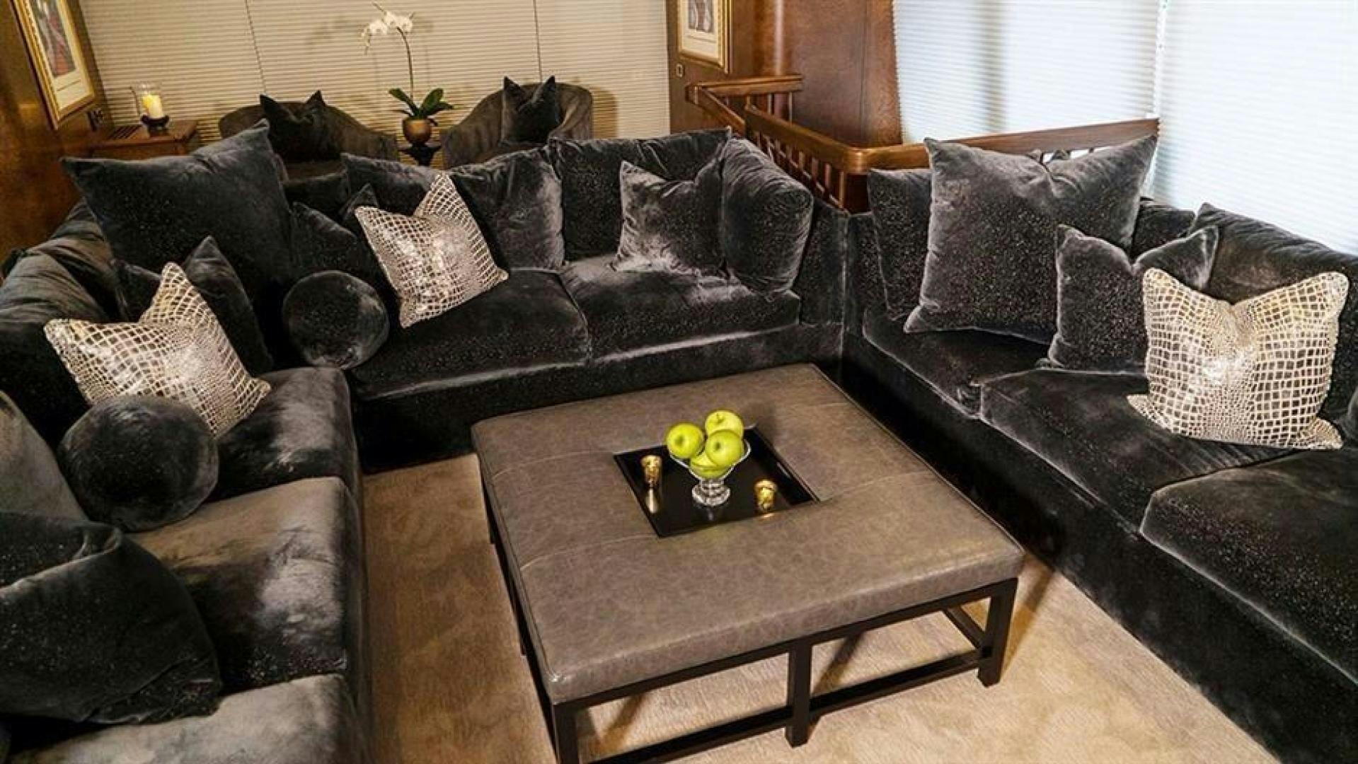 a living room with black couches and a coffee table aboard GRAND ILLUSION Yacht for Sale
