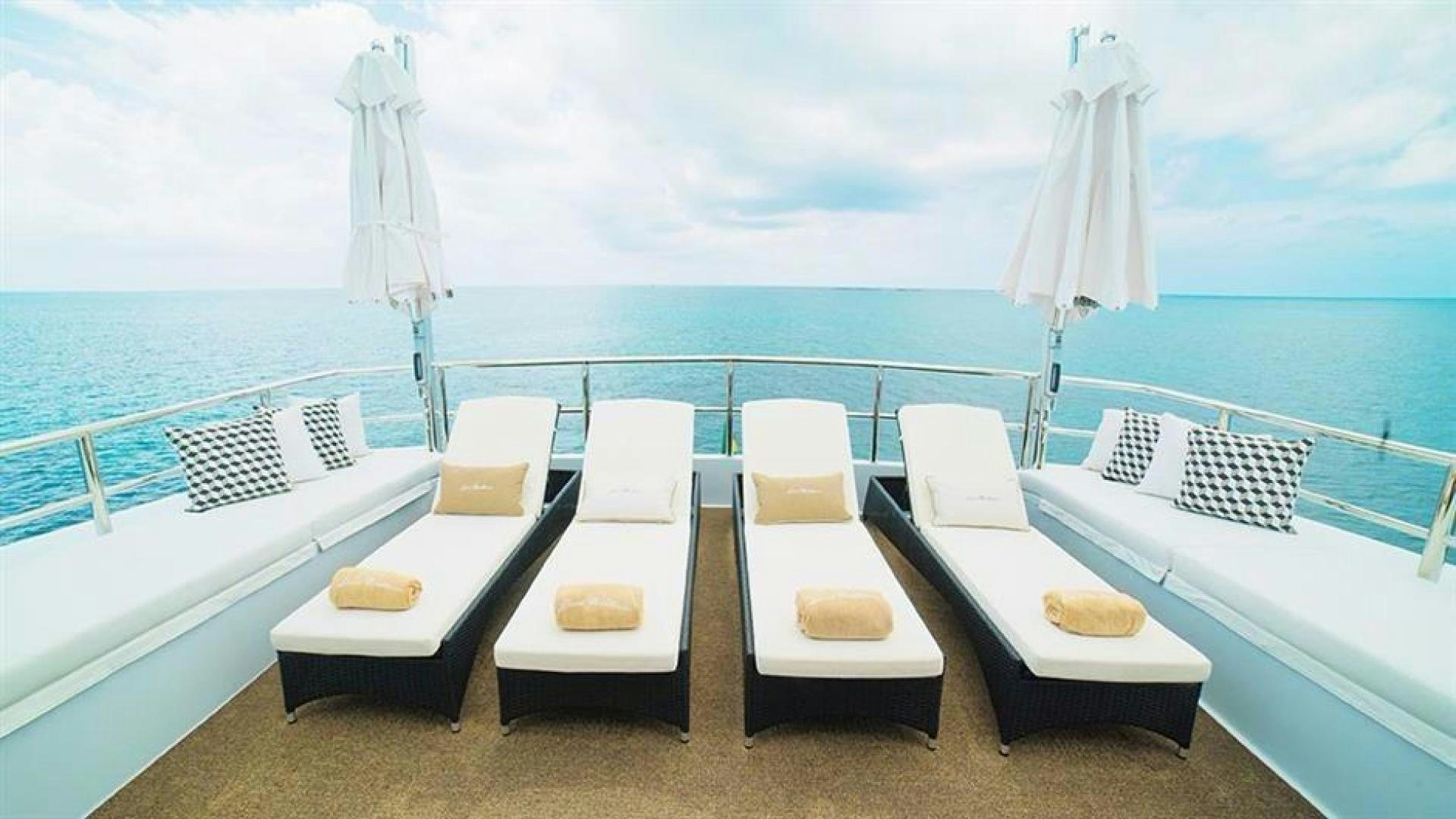 a room with a table chairs and a view of the ocean aboard GRAND ILLUSION Yacht for Sale
