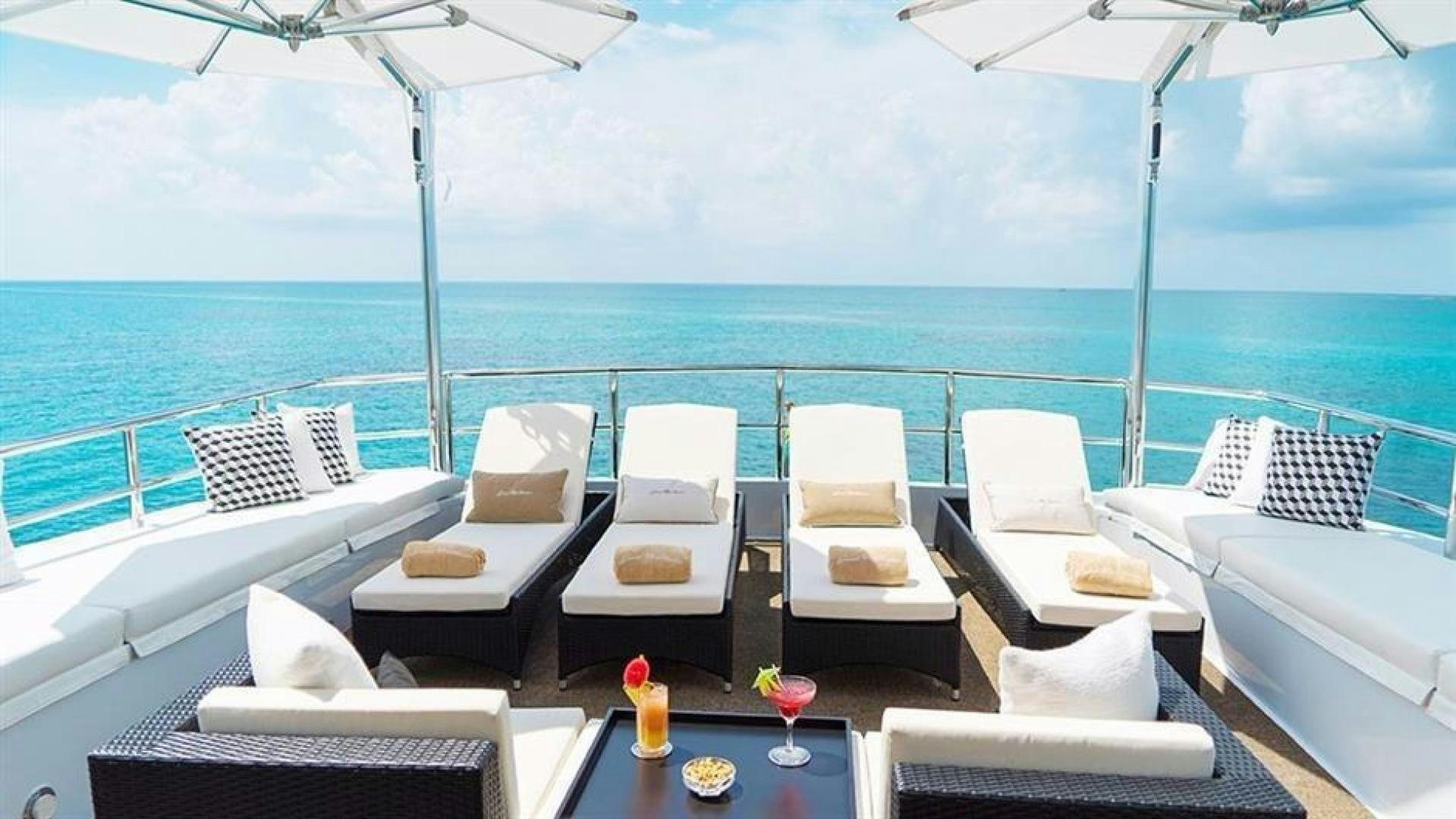 a room with a table chairs and a large body of water aboard GRAND ILLUSION Yacht for Sale