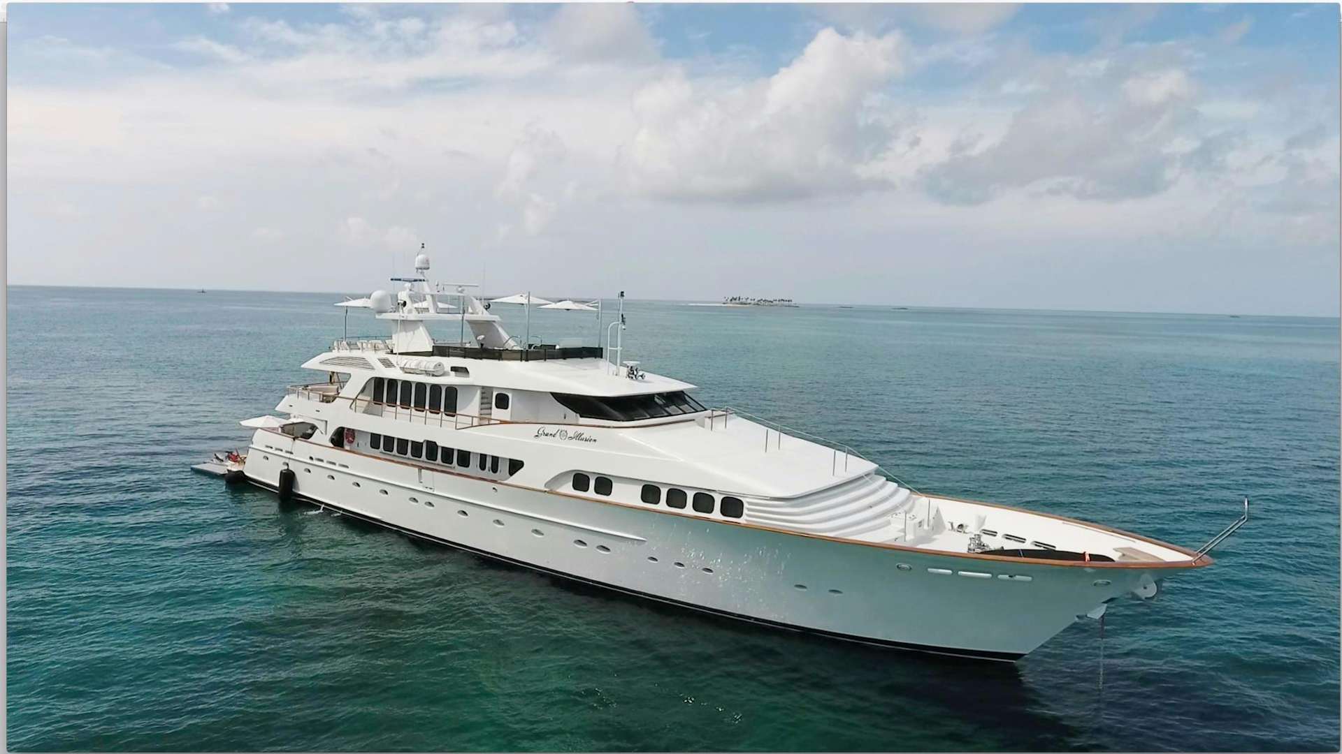 a large white yacht in the ocean aboard GRAND ILLUSION Yacht for Sale