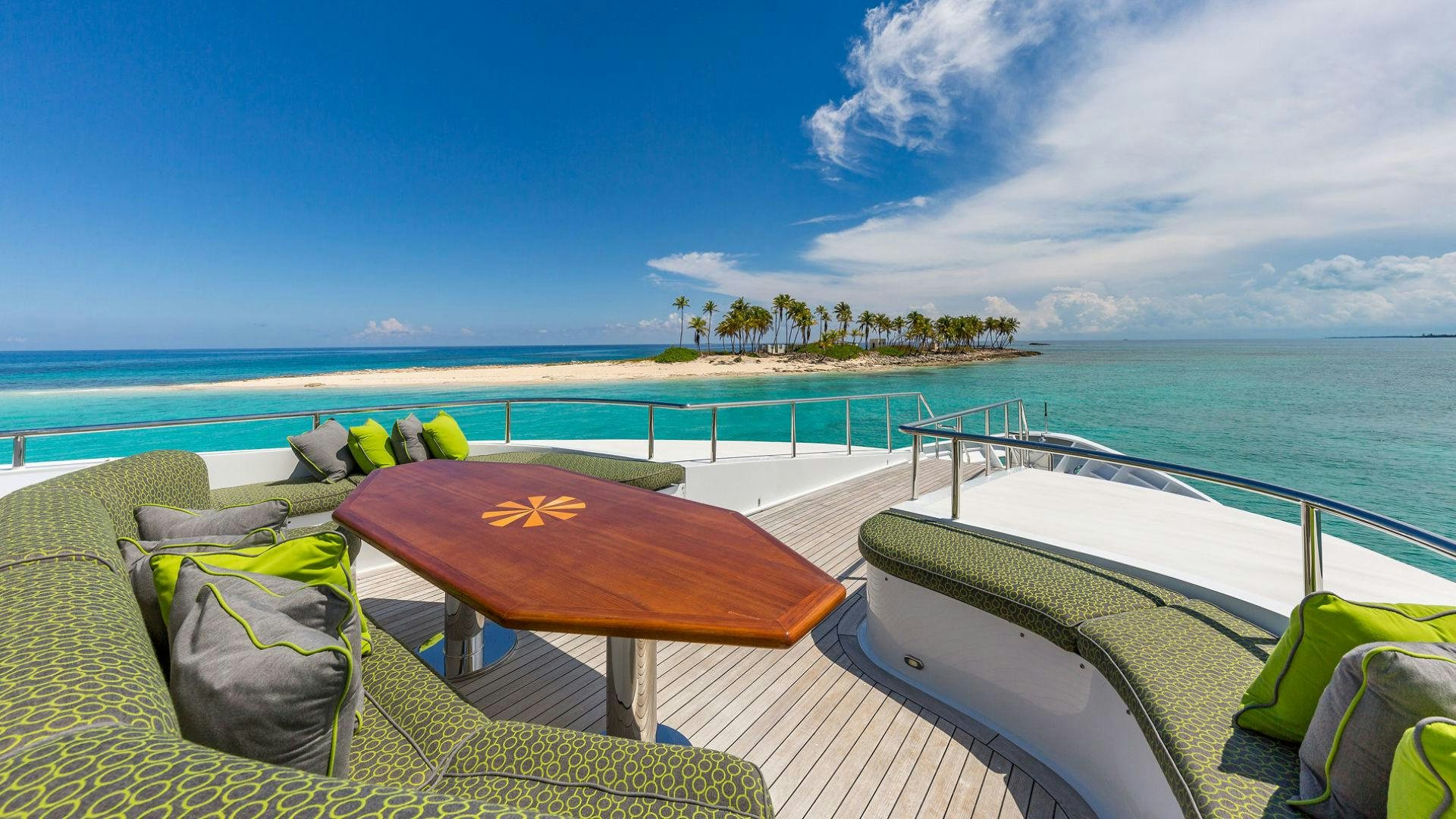 a deck with a view of the ocean and beach aboard AT LAST Yacht for Sale
