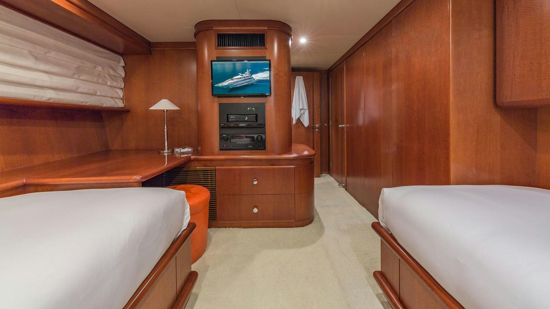 a room with a bed and a television aboard AT LAST Yacht for Sale