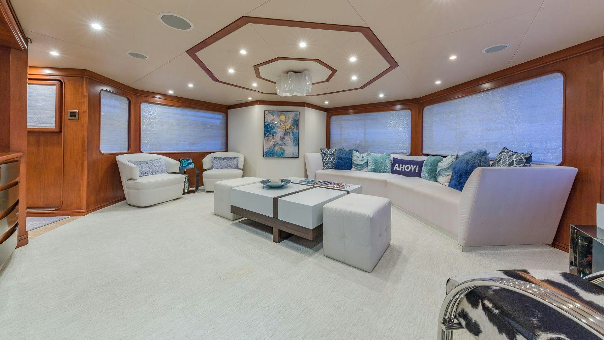a large living room with a large white couch and a large window aboard AT LAST Yacht for Sale