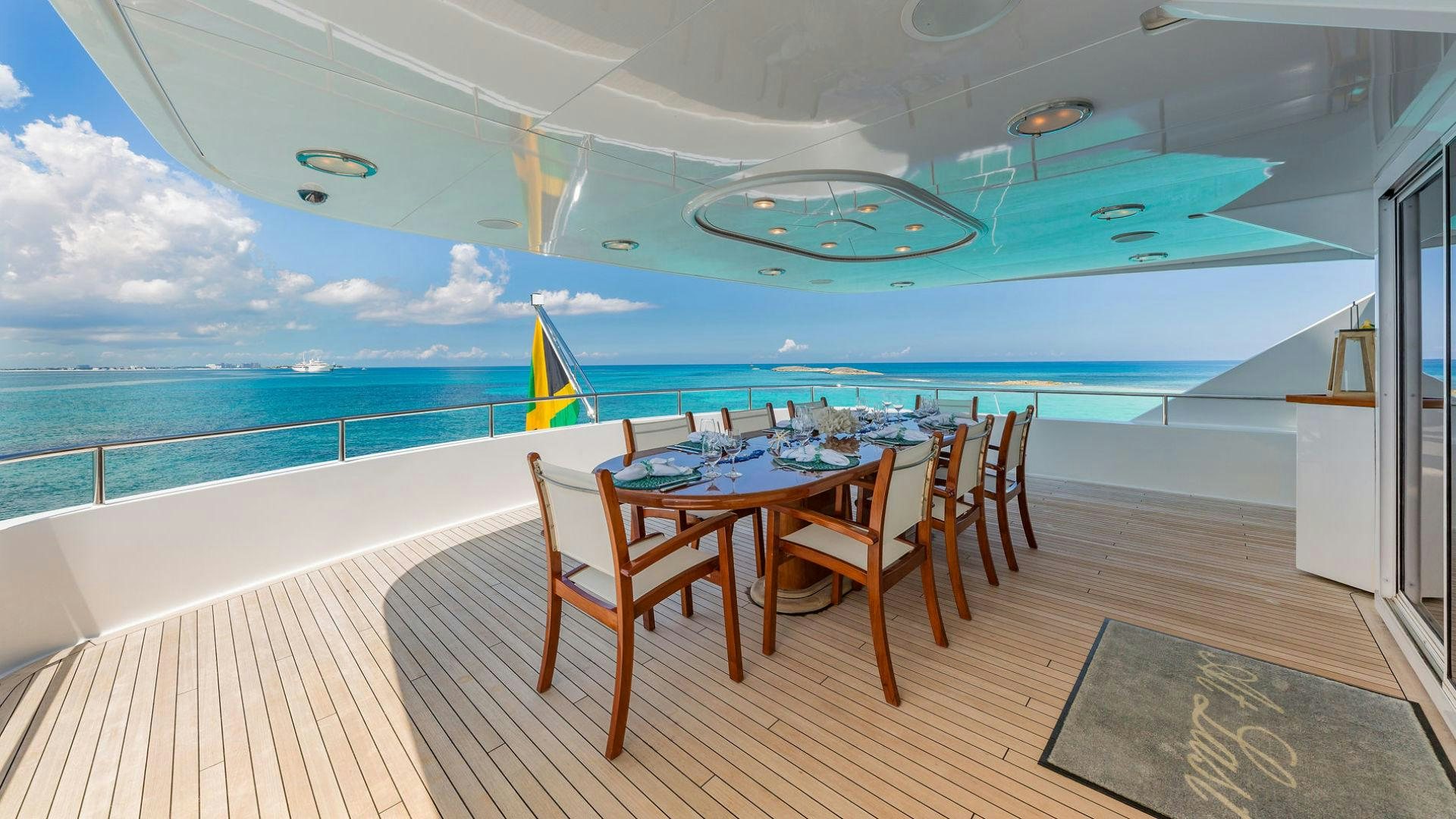 a table and chairs on a deck overlooking a pool aboard AT LAST Yacht for Sale