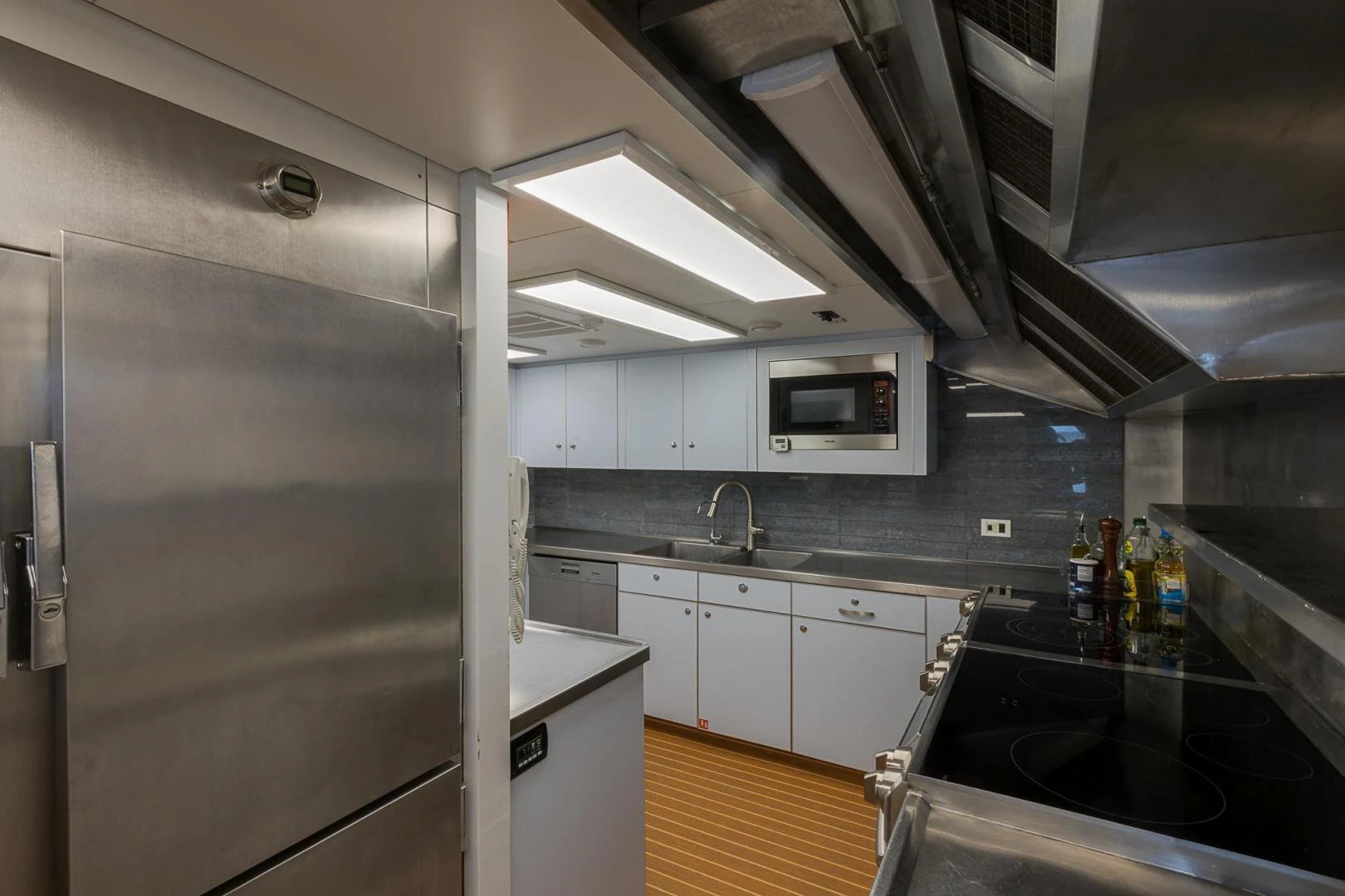 a kitchen with white cabinets aboard TRUE NORTH Yacht for Sale