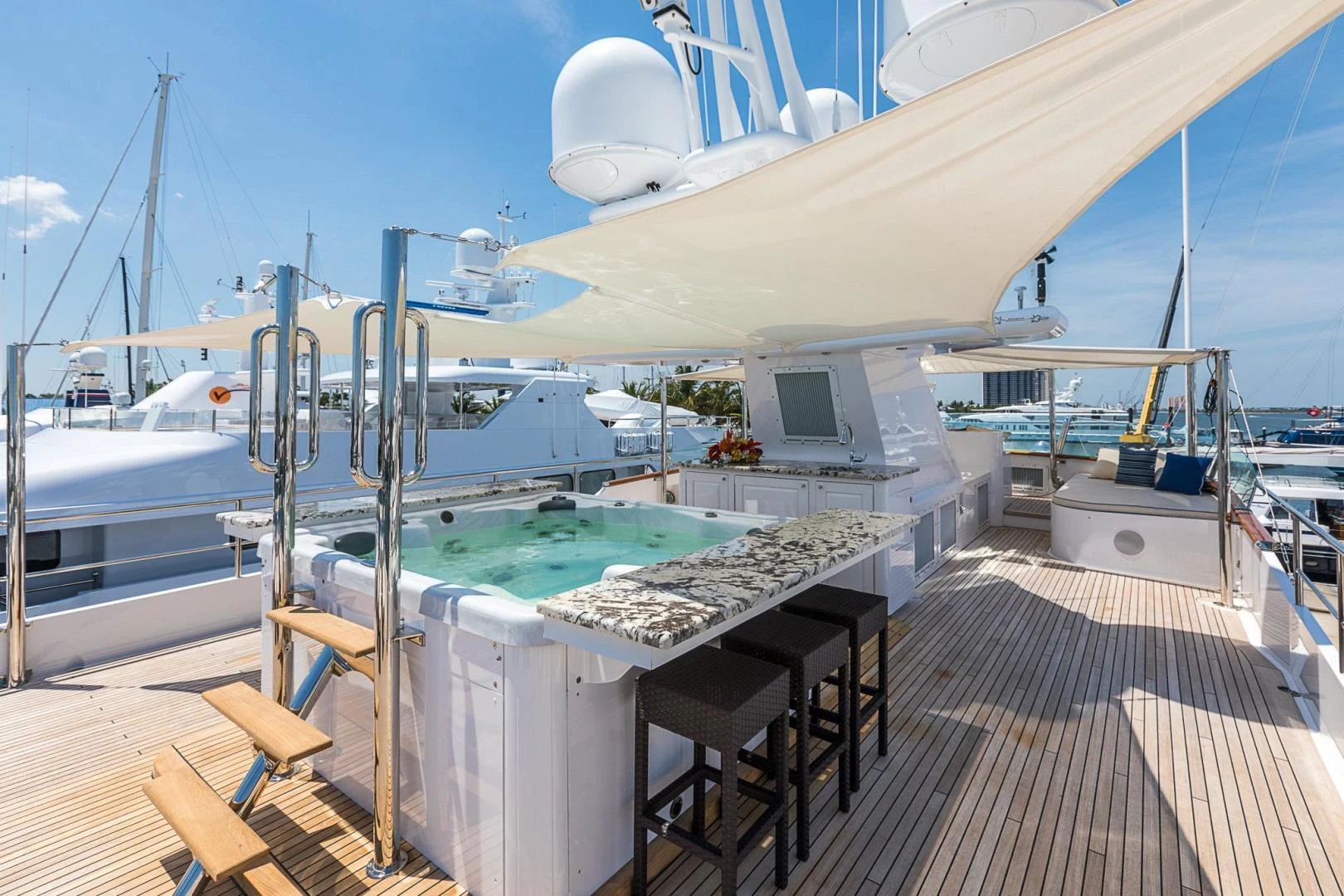 a deck with a pool and a deck with boats in the water aboard TRUE NORTH Yacht for Sale