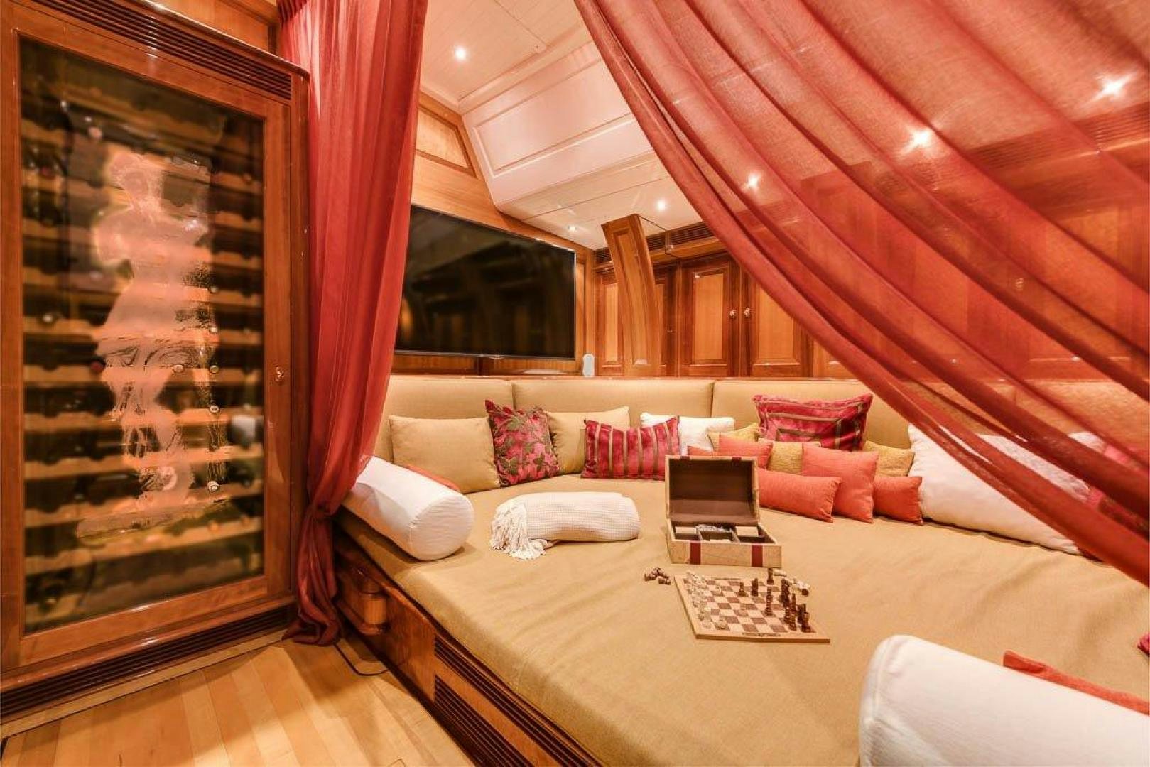 a bed with a red curtain aboard DELUSHA Yacht for Sale