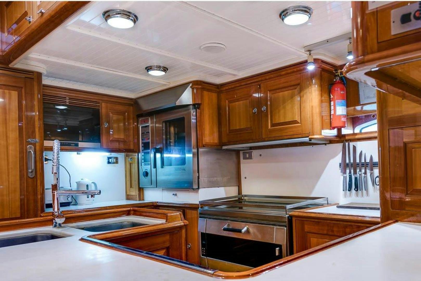 a kitchen with wooden cabinets aboard DELUSHA Yacht for Sale