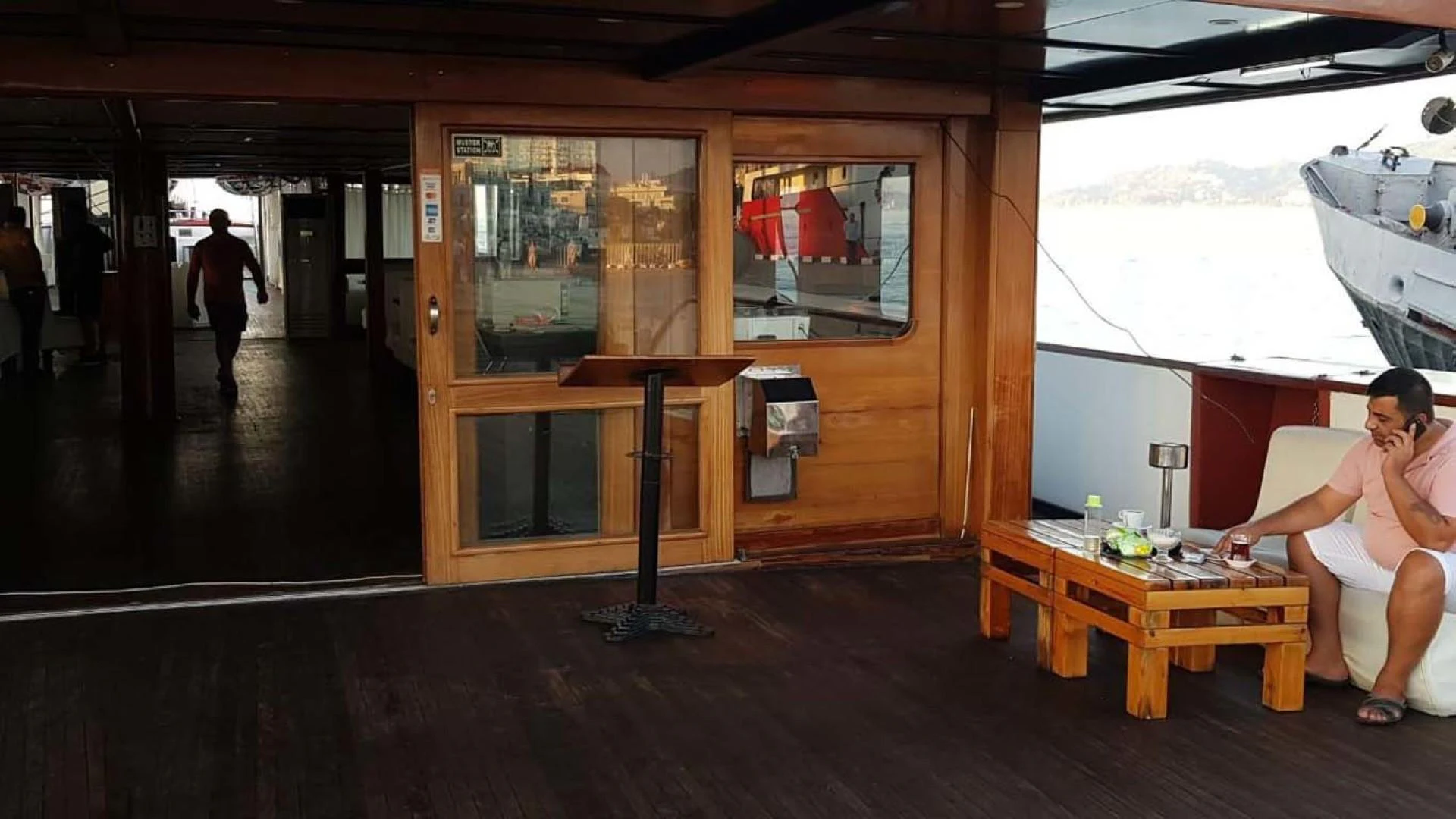 a person sitting on a bench in a room with a table and a window aboard MY DREAM Yacht for Sale