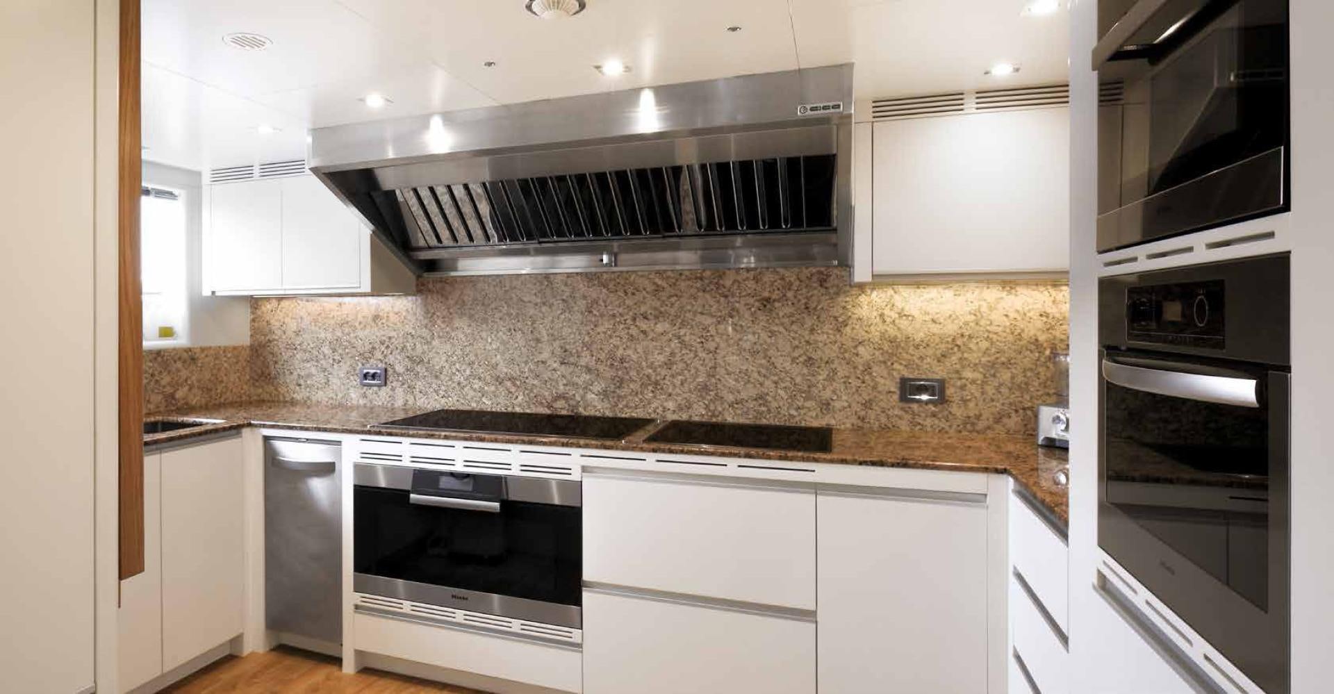 a kitchen with white cabinets aboard DREW Yacht for Sale