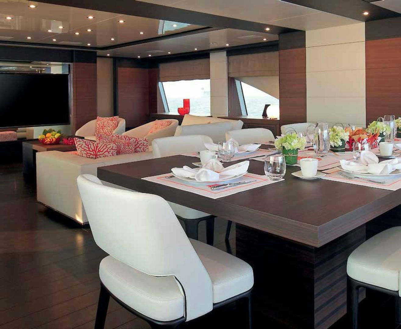 a dining table with chairs and a couch aboard DREW Yacht for Sale