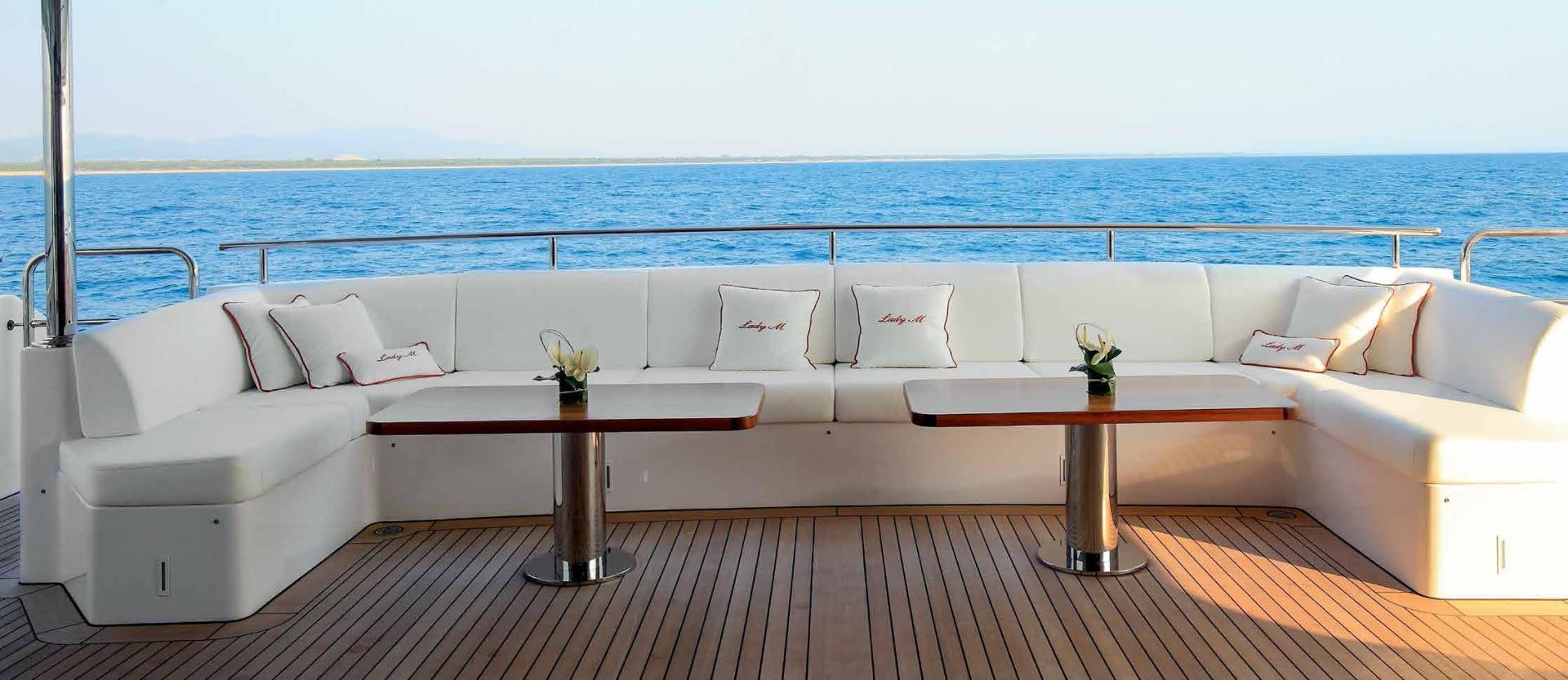 a white couch with a table on it by a large body of water aboard DREW Yacht for Sale