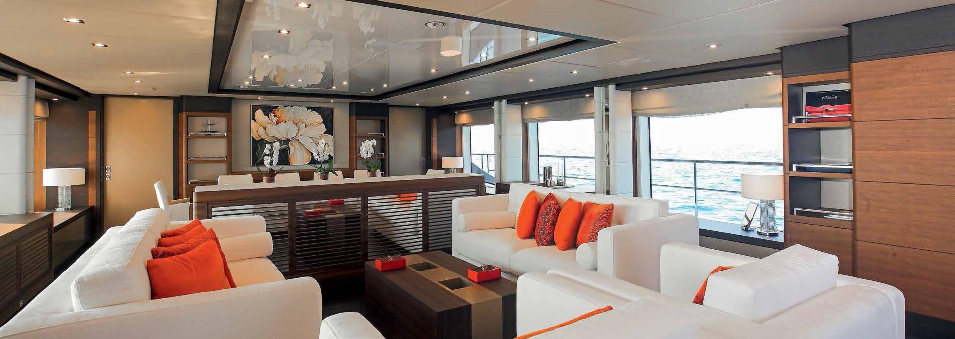 a room with a couch and a table and a shelf with books aboard DREW Yacht for Sale