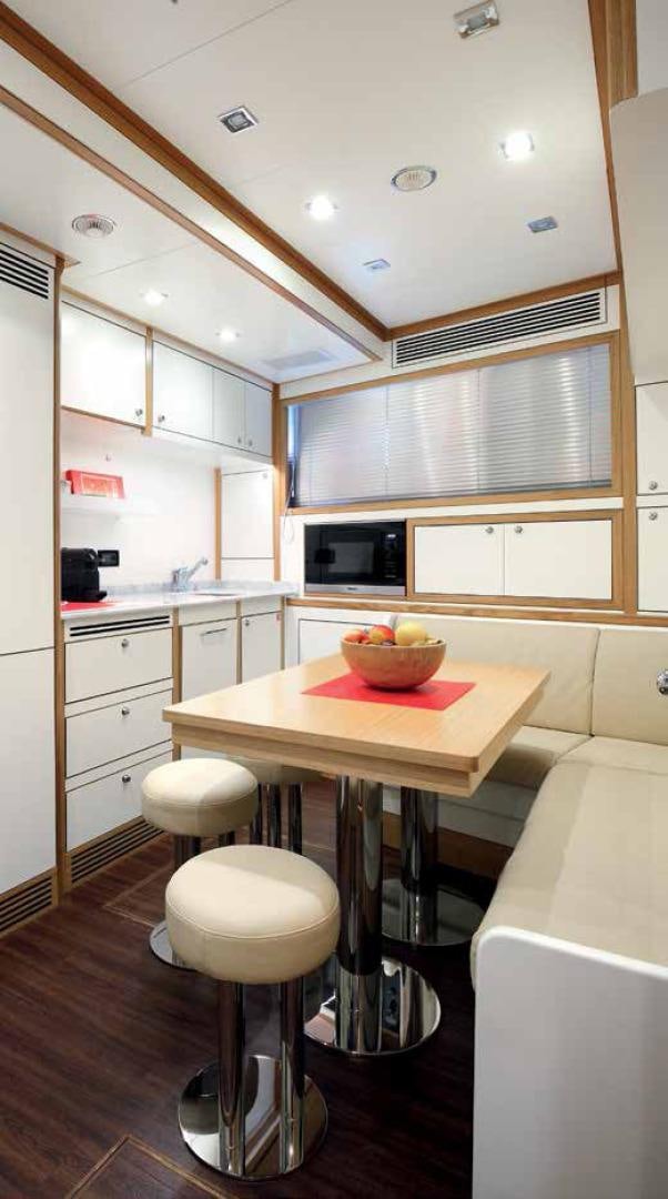 a kitchen with a table and stools aboard DREW Yacht for Sale