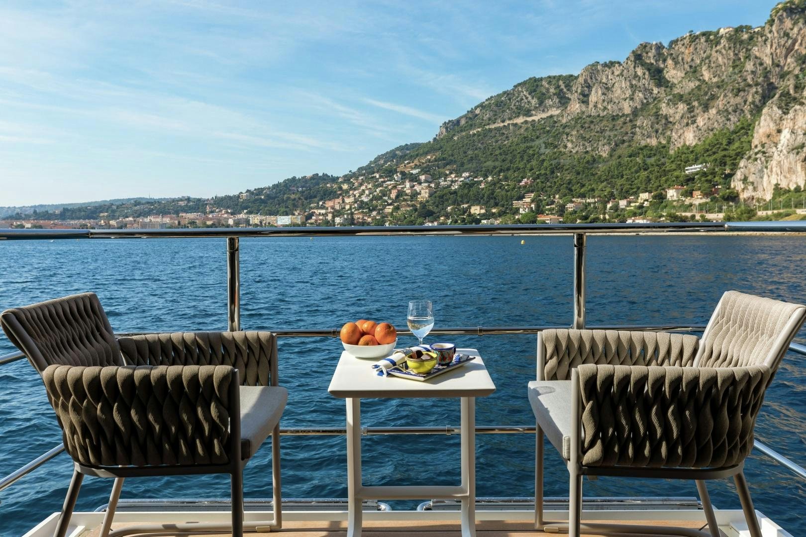 a table and chairs on a deck overlooking a body of water aboard ALTAVITA Yacht for Sale