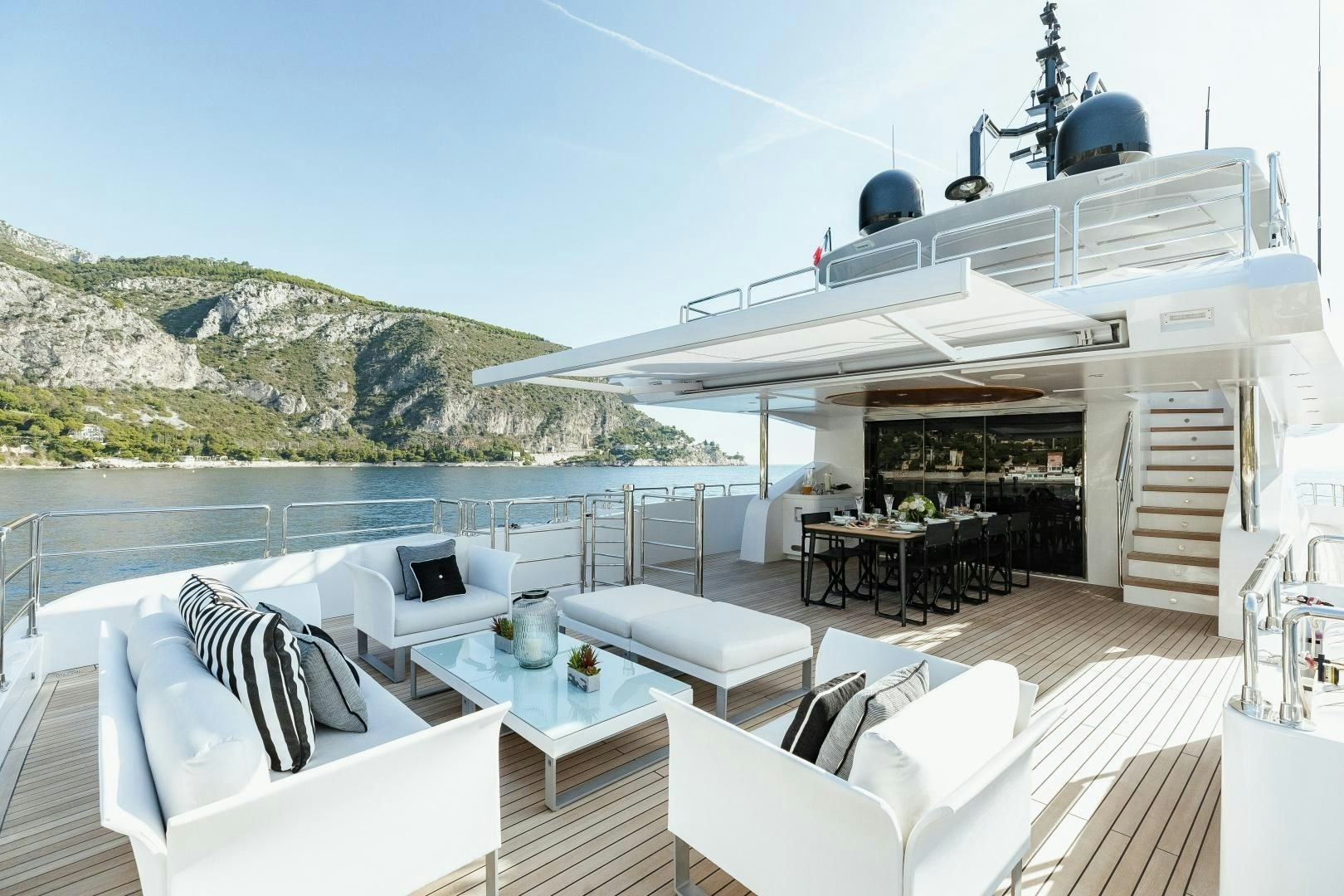 a deck with a table and chairs on it aboard ALTAVITA Yacht for Sale