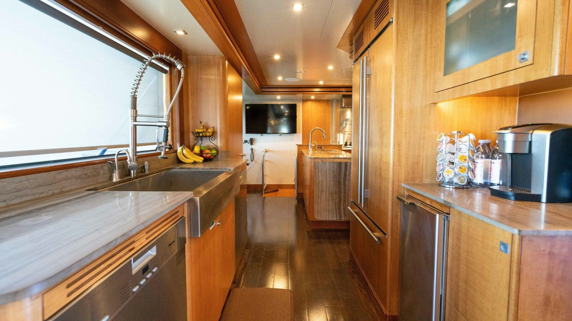 a kitchen with wooden cabinets aboard SERENITY Yacht for Sale