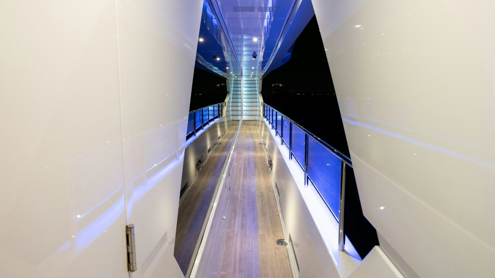 a long hallway with blue and white striped walls aboard SERENITY Yacht for Sale