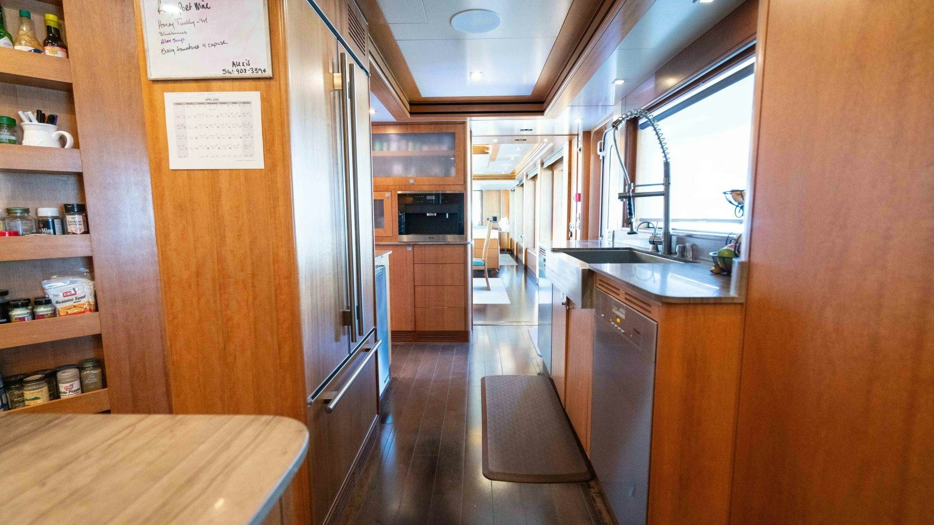 a kitchen with wooden cabinets aboard SERENITY Yacht for Sale