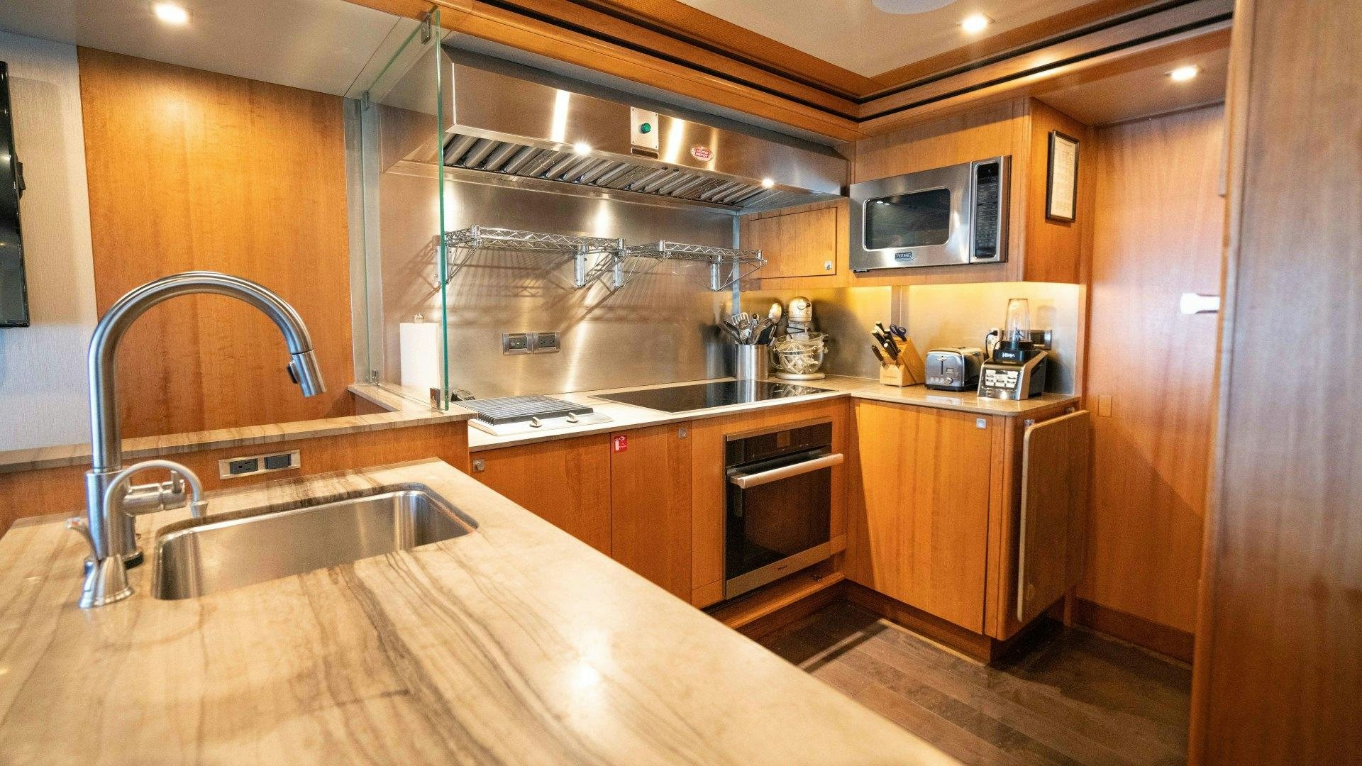 a kitchen with wooden cabinets aboard SERENITY Yacht for Sale