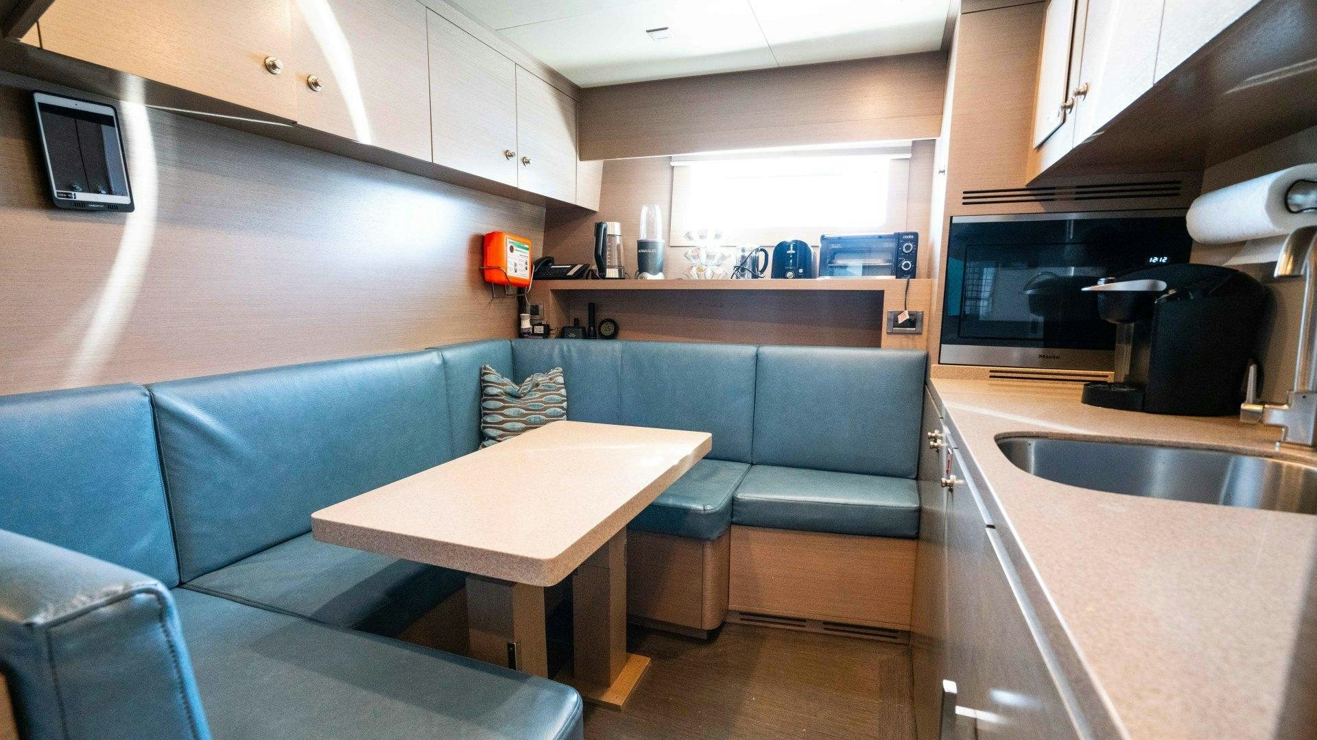 a kitchen with a table and chairs aboard SERENITY Yacht for Sale