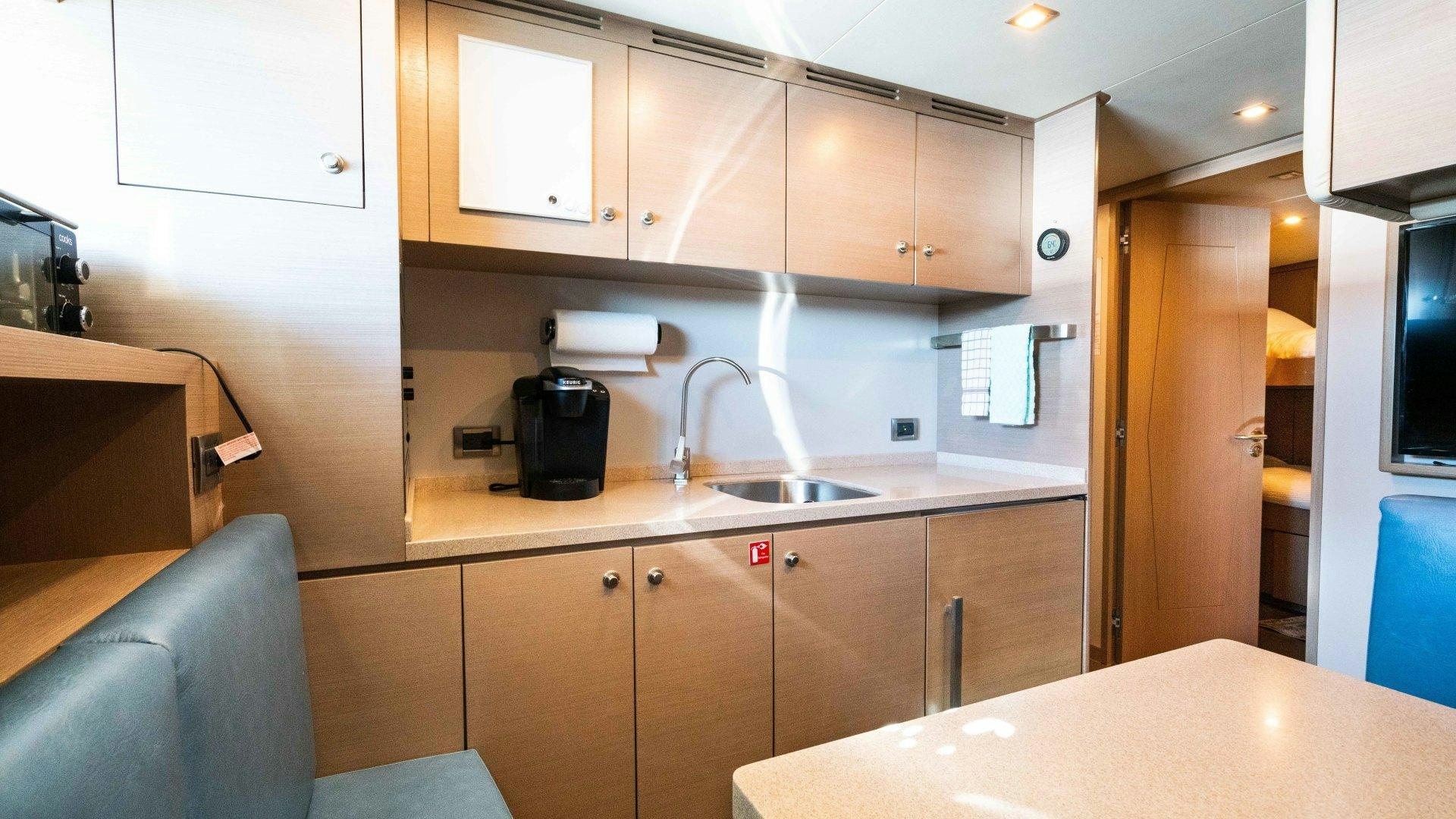 a kitchen with wooden cabinets aboard SERENITY Yacht for Sale