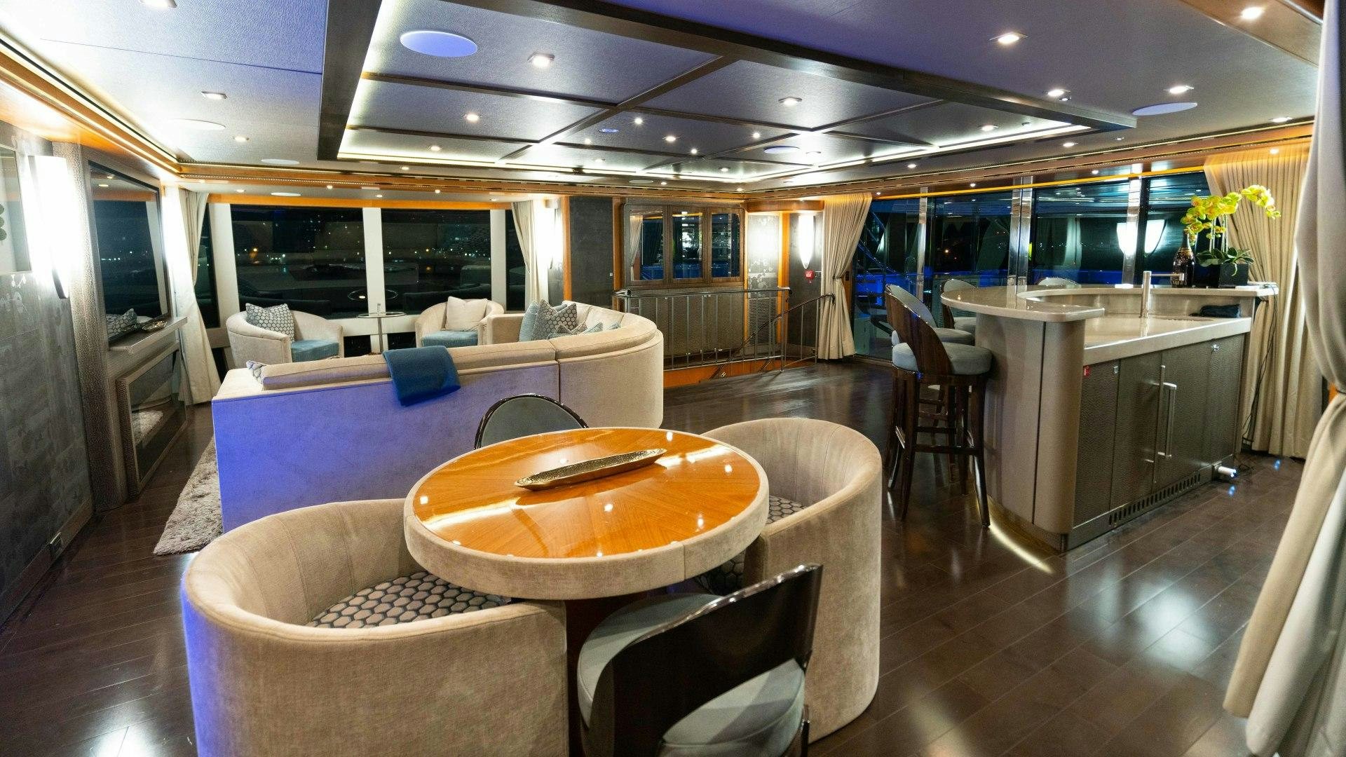 a room with a table and chairs aboard SERENITY Yacht for Sale