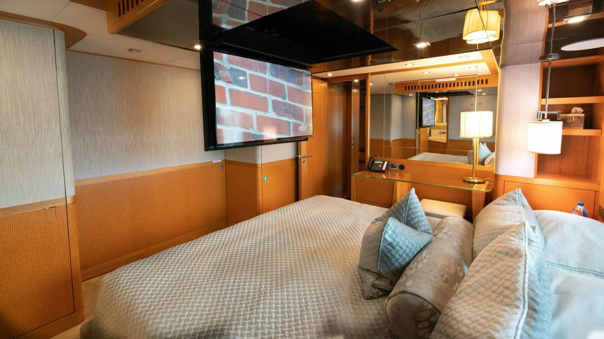 a bed with a white comforter aboard SERENITY Yacht for Sale