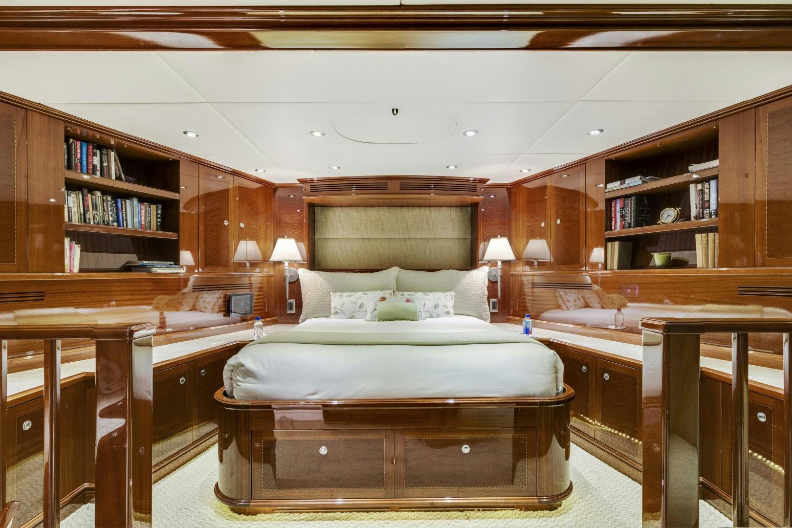 a bedroom with a bed and a bookcase aboard SERQUE Yacht for Sale